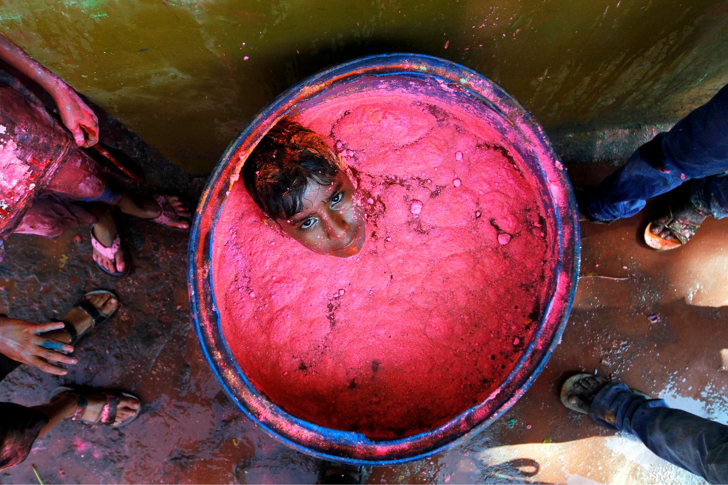 A boy sits in a plastic container filled with coloured water during Holi celebrations in the southern Indian city of Chennai March 16, 2014. Holi, also known as the Festival of Colours, heralds the beginning of spring and is celebrated all over India.