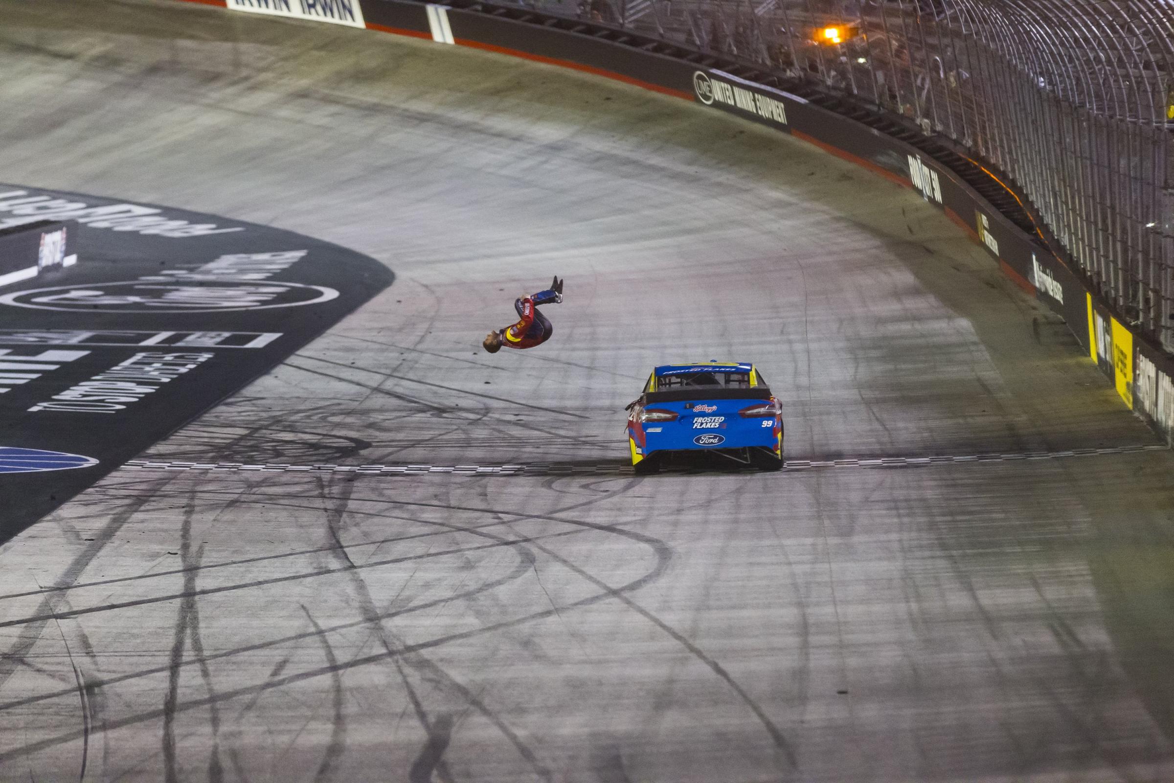Driver Carl Edwards does a back flip off of the Roush Fenway Racing #99 Ford Fusion after winning the Sprint Cup series Food City 500 at Bristol Motor Speedway in Bristol, Tenn.
