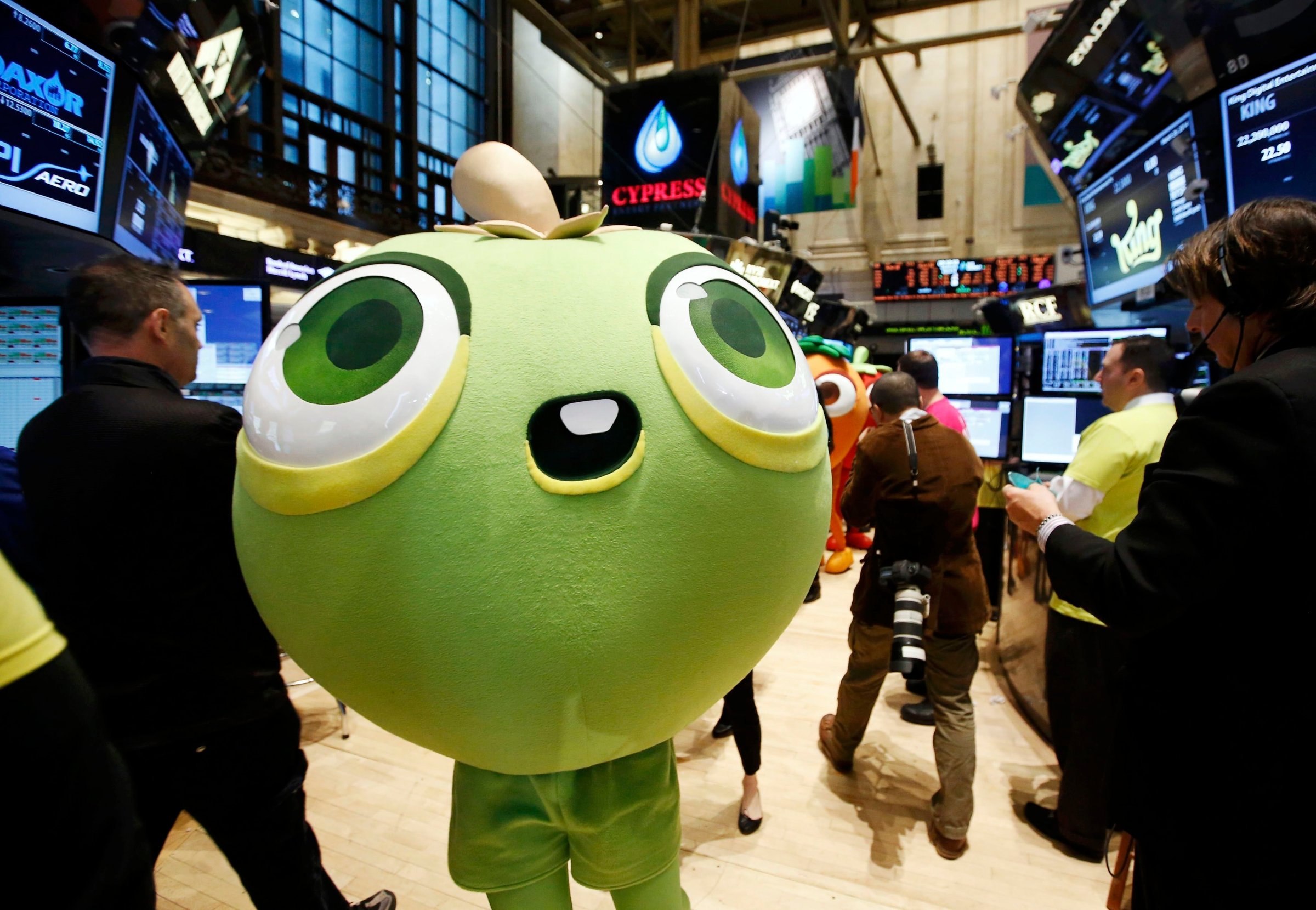 A mascot dressed as a character from the mobile game "Candy Crush Saga" walks the floor of the New York Stock Exchange during the IPO of Mobile game maker King Digital Entertainment Plc