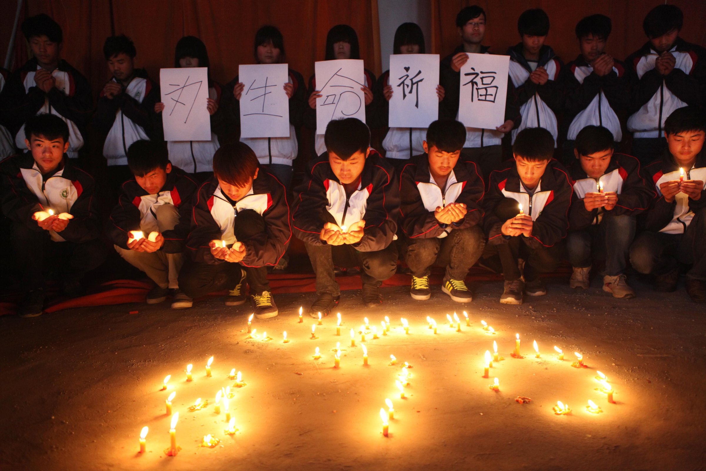 High school students in Lianyungang in Chinas eastern Jiangsu province hold a vigil for the passengers and crew of Flight MH 370