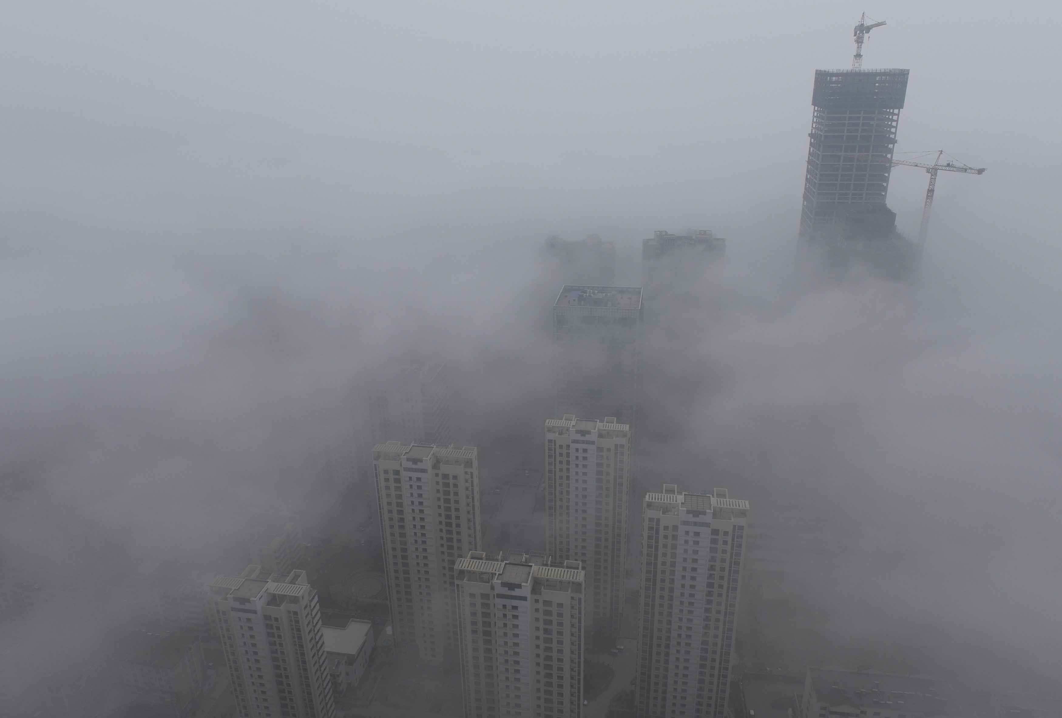 Buildings are seen shrouded in heavy haze at Qingdao development zone, Shandong province