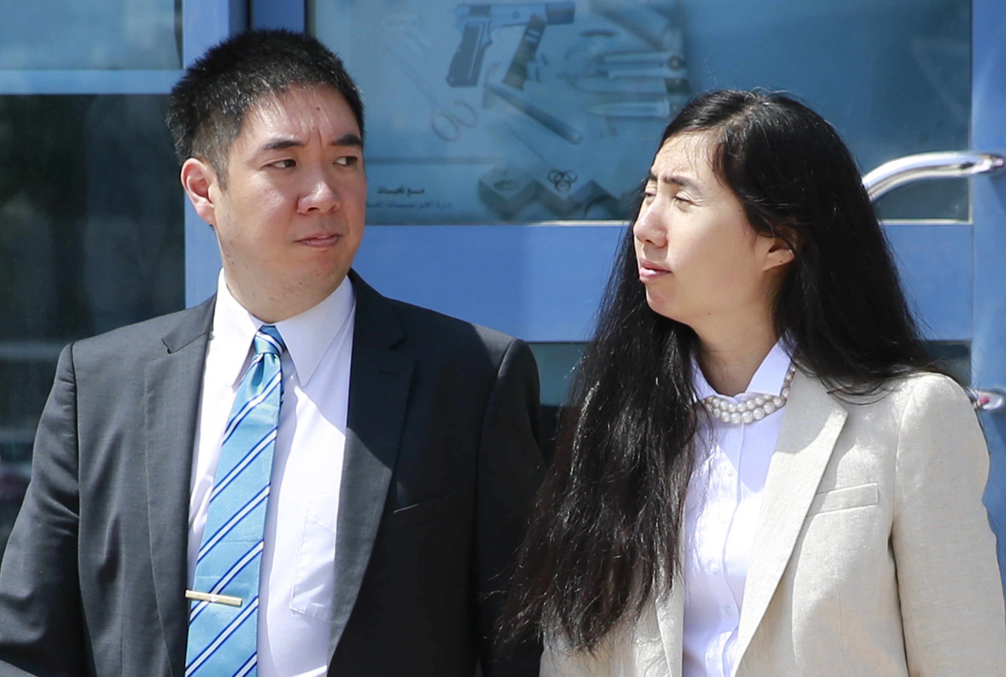 Matthew and Grace Huang, an American couple charged with starving their 8-year-old adopted daughter to death, stand outside the entrance of the Court of First Instance after their trial in Doha, March 27, 2014. (Mohammed Dabbous—Reuters)