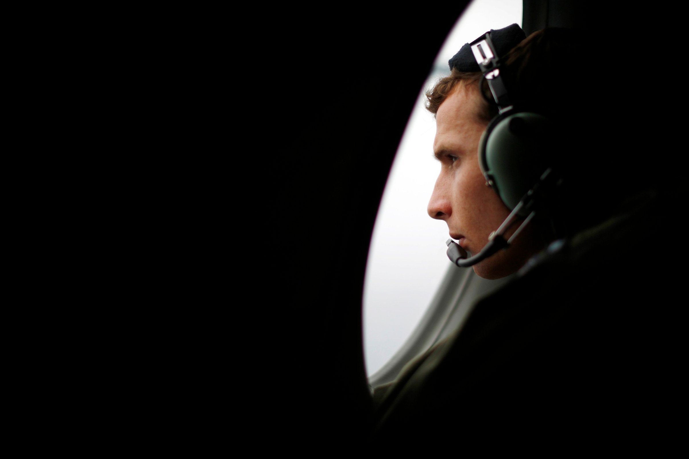 A crew member aboard a Royal New Zealand Air Force P-3K2 Orion aircraft searches for missing Malaysian Airlines flight MH370 over the southern Indian Ocean