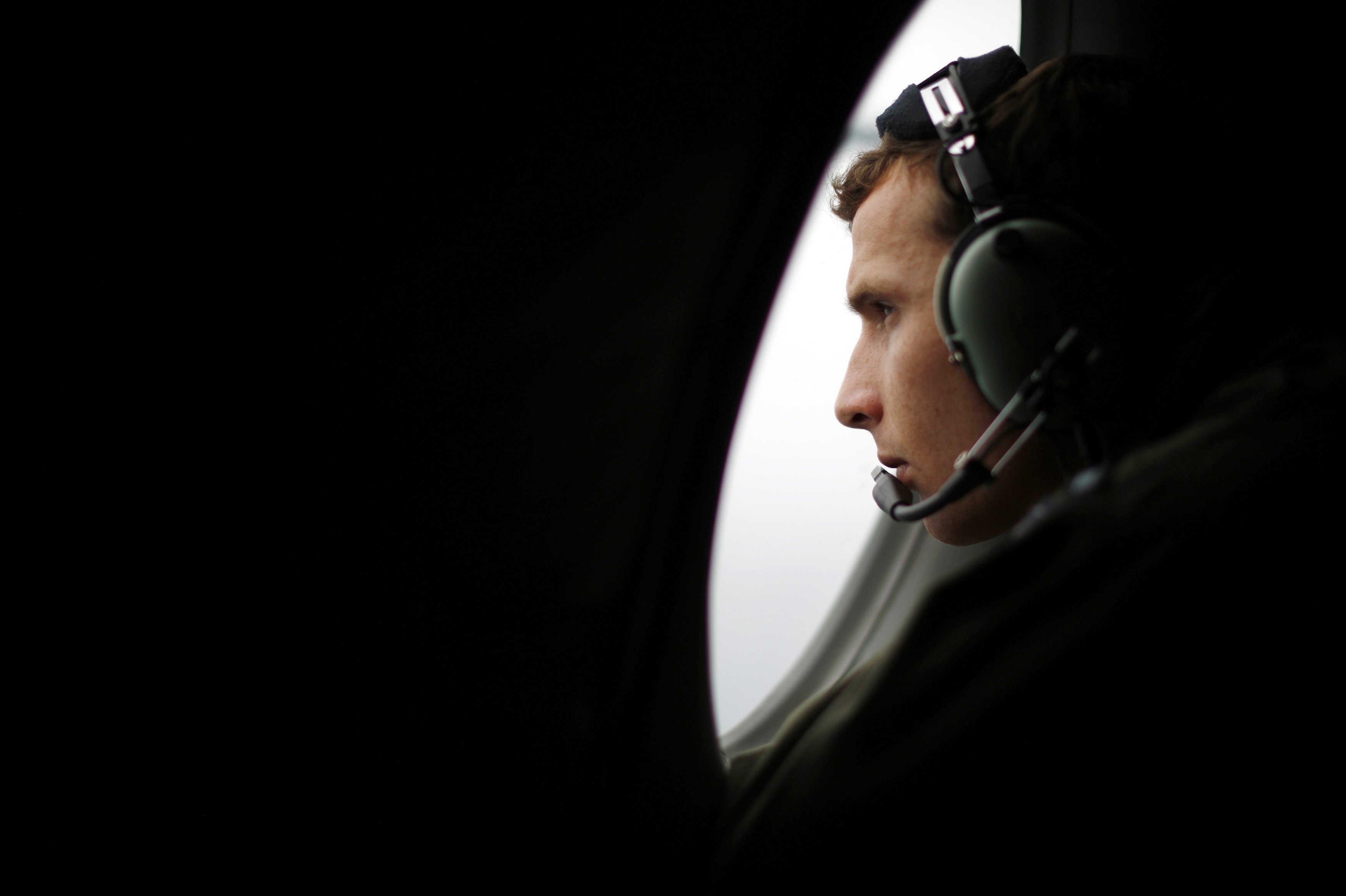 A crew member aboard a Royal New Zealand Air Force P-3K2 Orion aircraft searches for missing Malaysian Airlines flight MH370 over the southern Indian Ocean