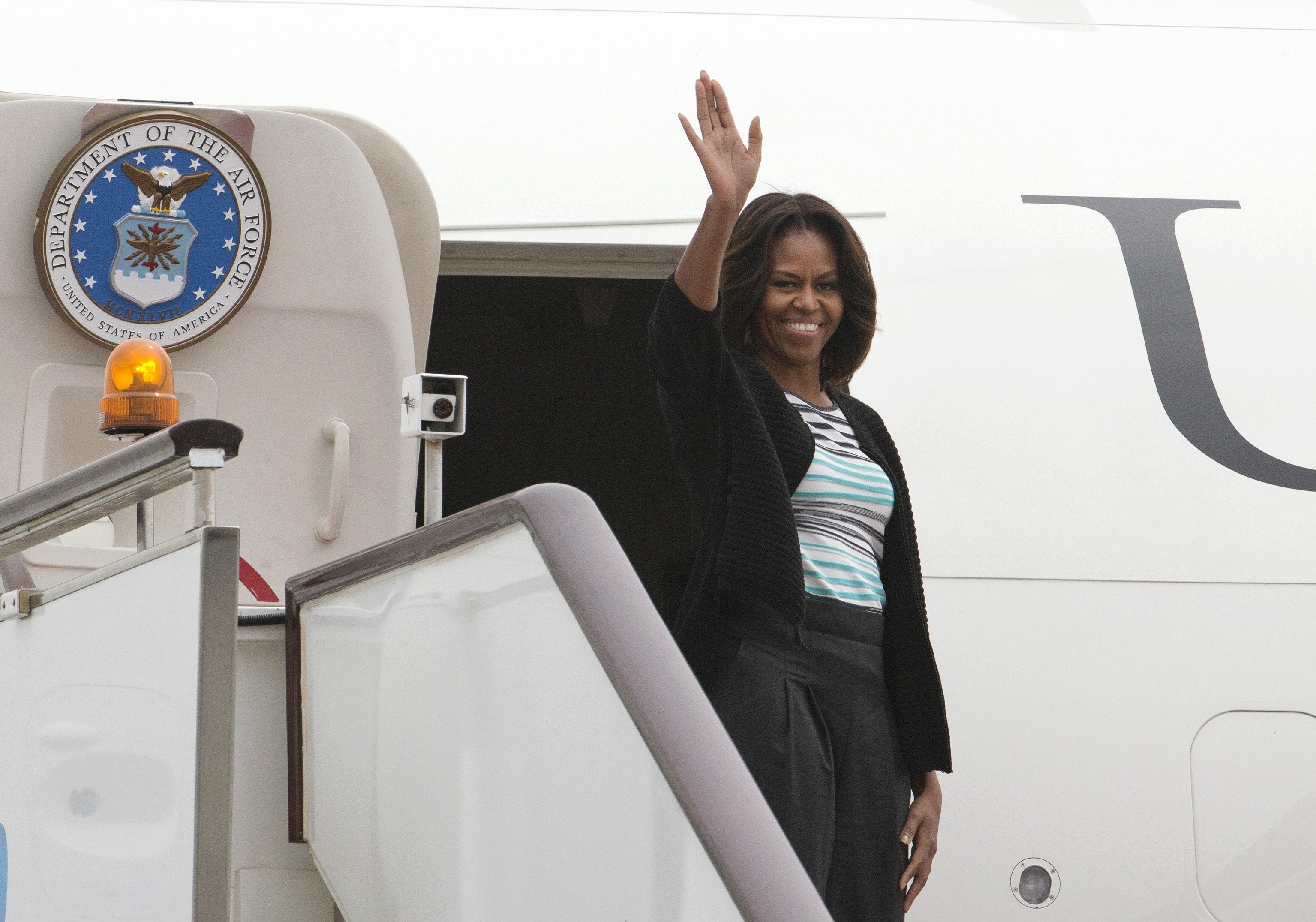U.S. first lady Michelle Obama waves before departing Chengdu Airport in southwest China's Sichuan province Wednesday, March 26, 2014.