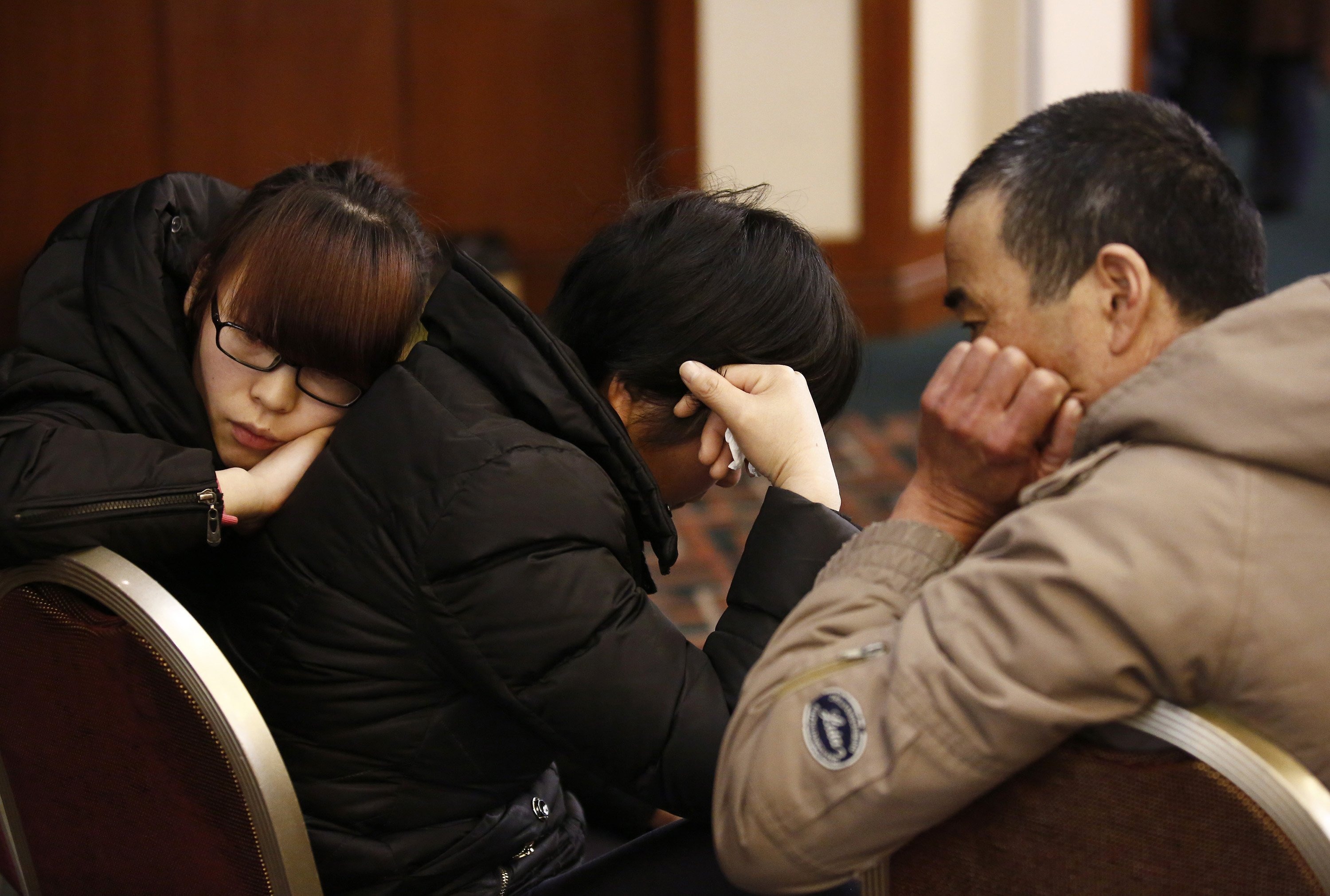 Family members of a passenger onboard the missing Malaysia Airlines flight MH370 react as they listen to a briefing from the airline company at a hotel in Beijing