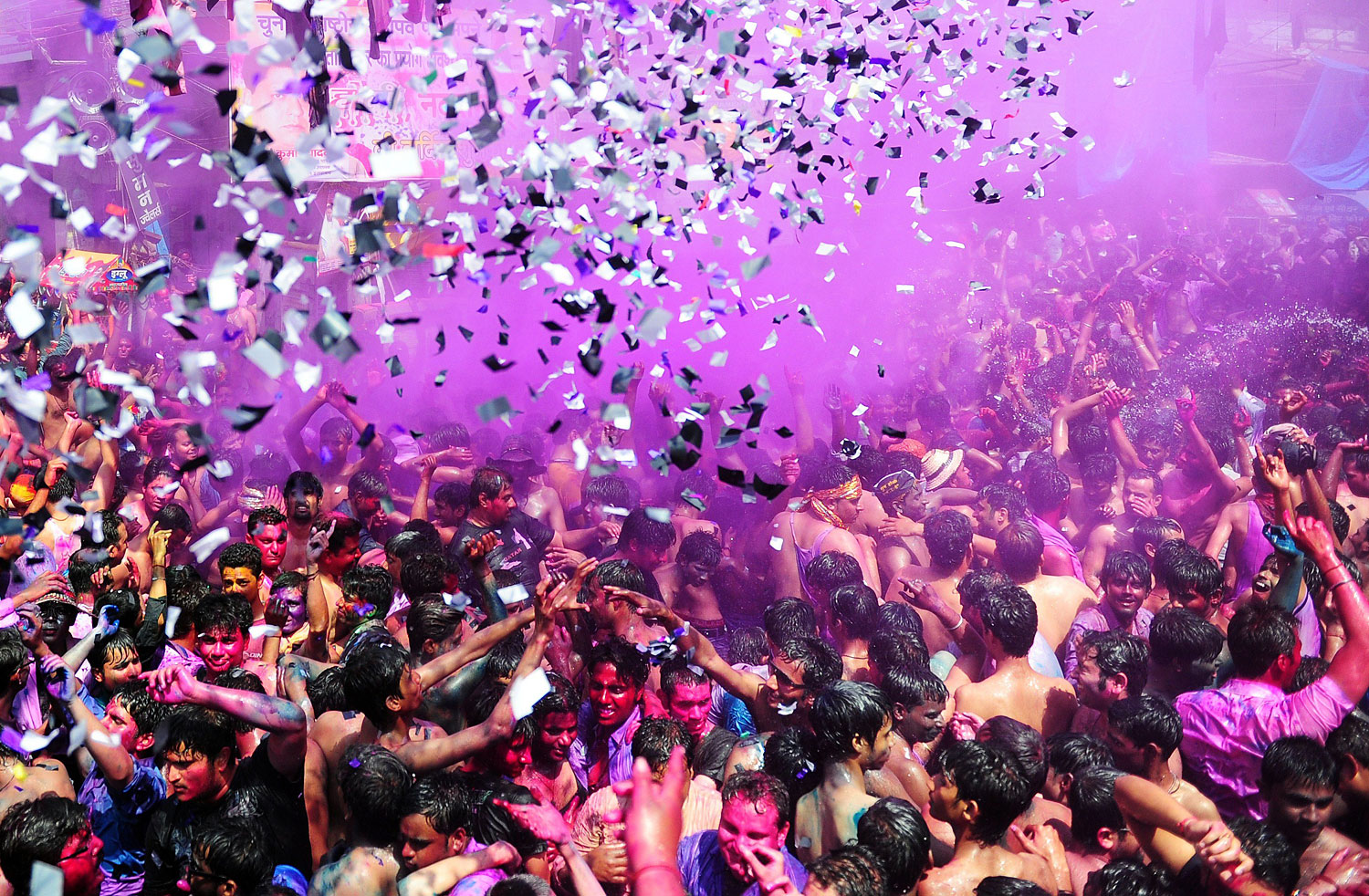 Indian revellers covered in coloured powder dance during Holi festival celebrations in Allahabad on March 17, 2014.