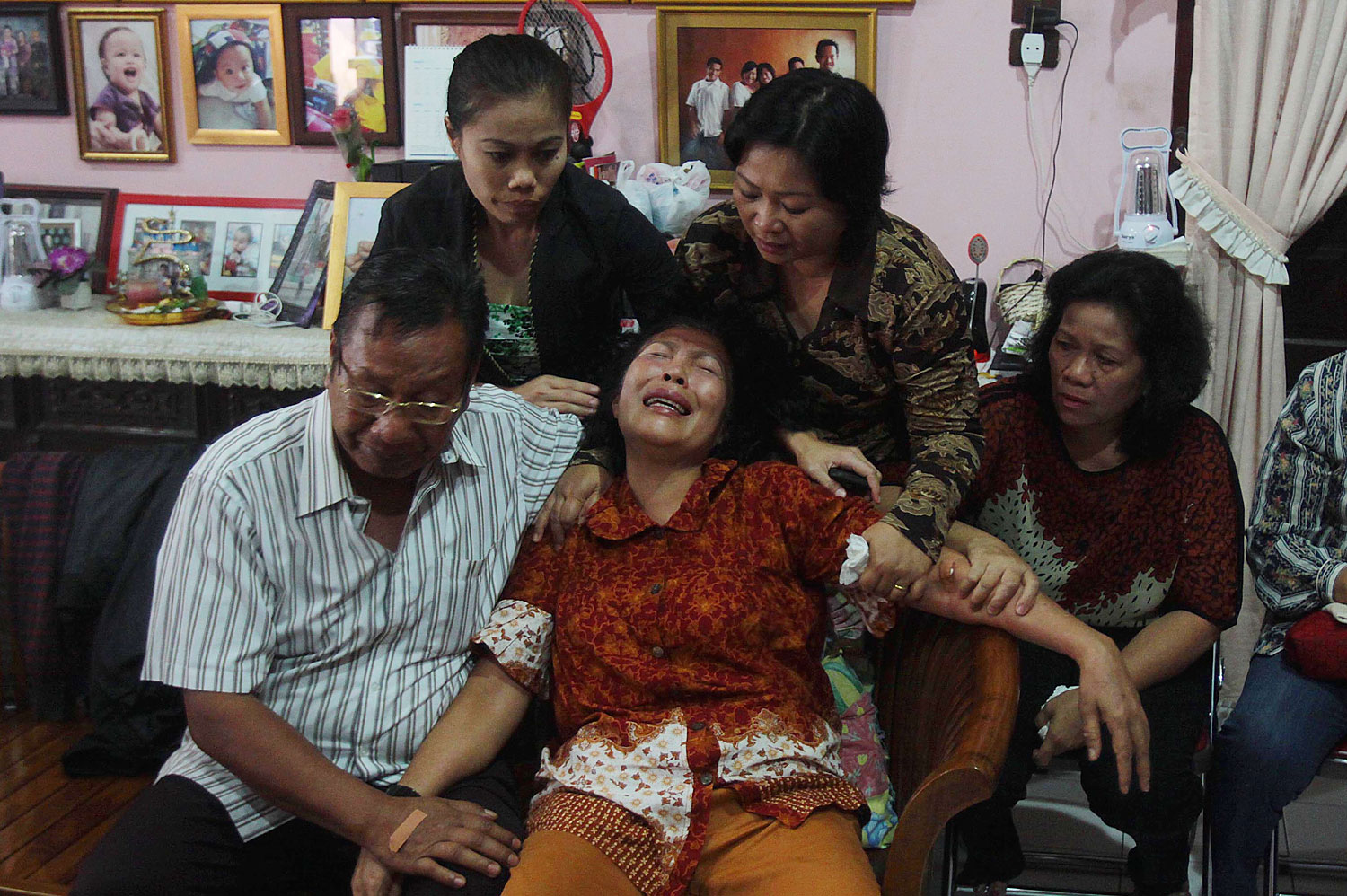 Risman Siregar, left, comforts his wife Erlina Panjaitan, center — both are parents of Firman Chandra Siregar, a 24-year-old Indonesian passenger of Malaysia Airlines Flight 370 — on March 9, 2014, in Medan, Indonesia (Atar—AFP/Getty Images)