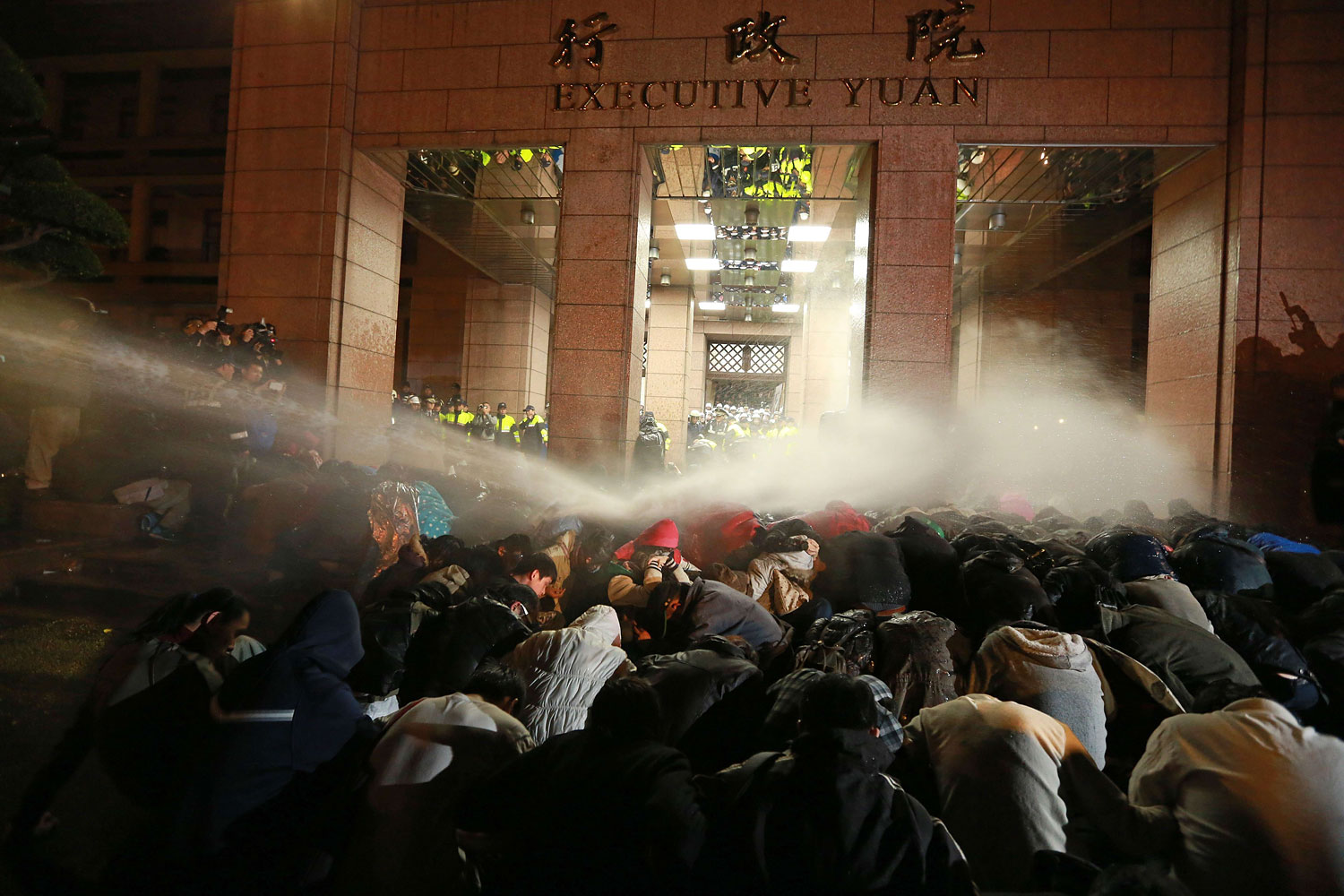 Protesters are sprayed with a water cannon during a demonstration outside the Executive Yuan in Taipei early on March 24, 2014, following Taiwan President Ma Ying-jeou's refusal to scrap a contentious trade agreement with China.