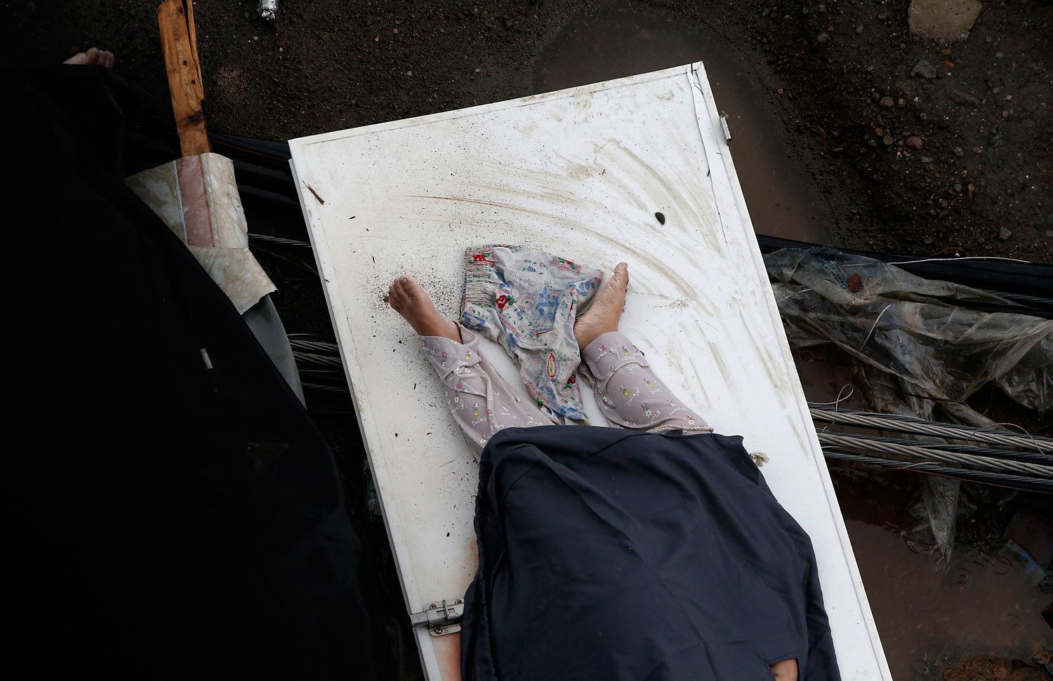 The body of a typhoon victim lies on a door after Typhoon Haiyan battered Tacloban city in central Philippines, November 10, 2013.