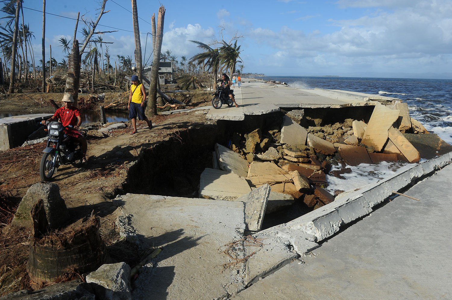 A motorist crosses a collapsed highway caused by the storm surge in Palo, in Leyte province, on Nov. 10, 2013