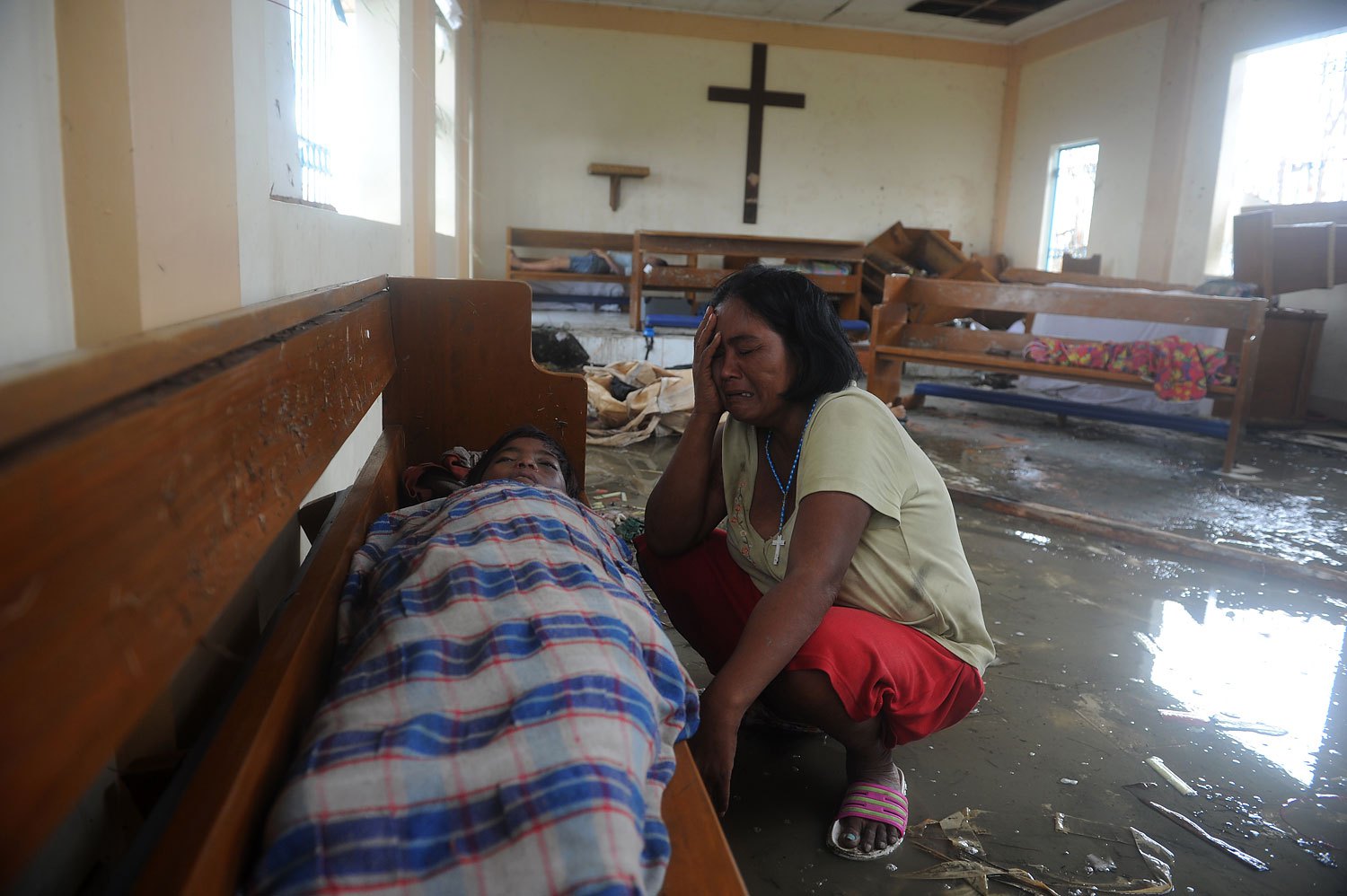 A mother weeps beside her dead son at a chapel in the aftermath of Supertyphoon Haiyan in Tacloban, in Leyte province, Nov. 9, 2013