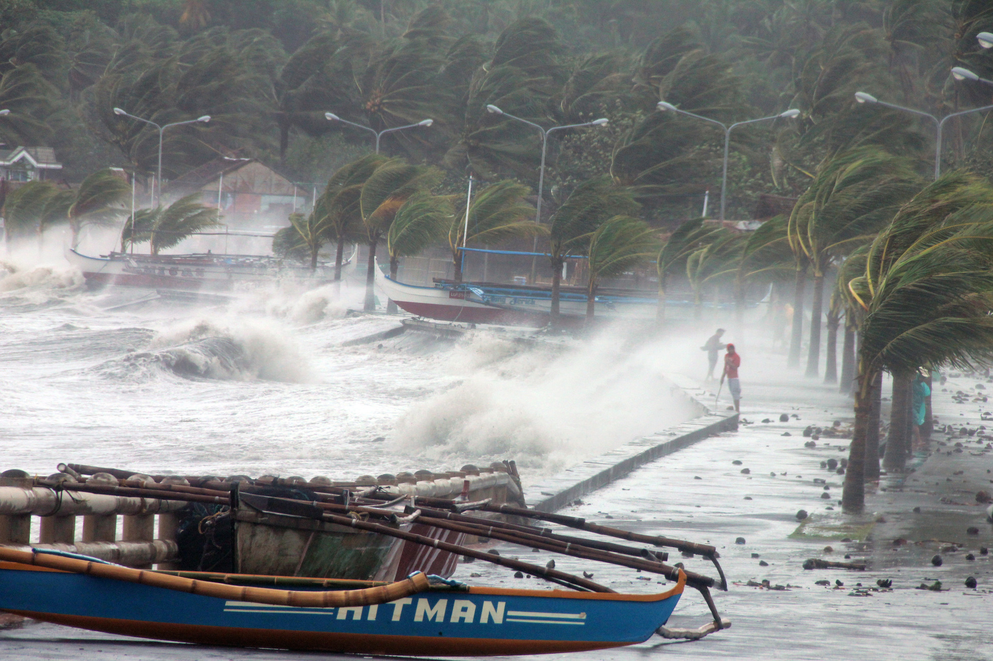 Residents stand along a sea wall as high waves pounded them amidst strong winds as Typhoon Haiyan hit the city of Legaspi, Albay province, south of Manila on November 8, 2013.
