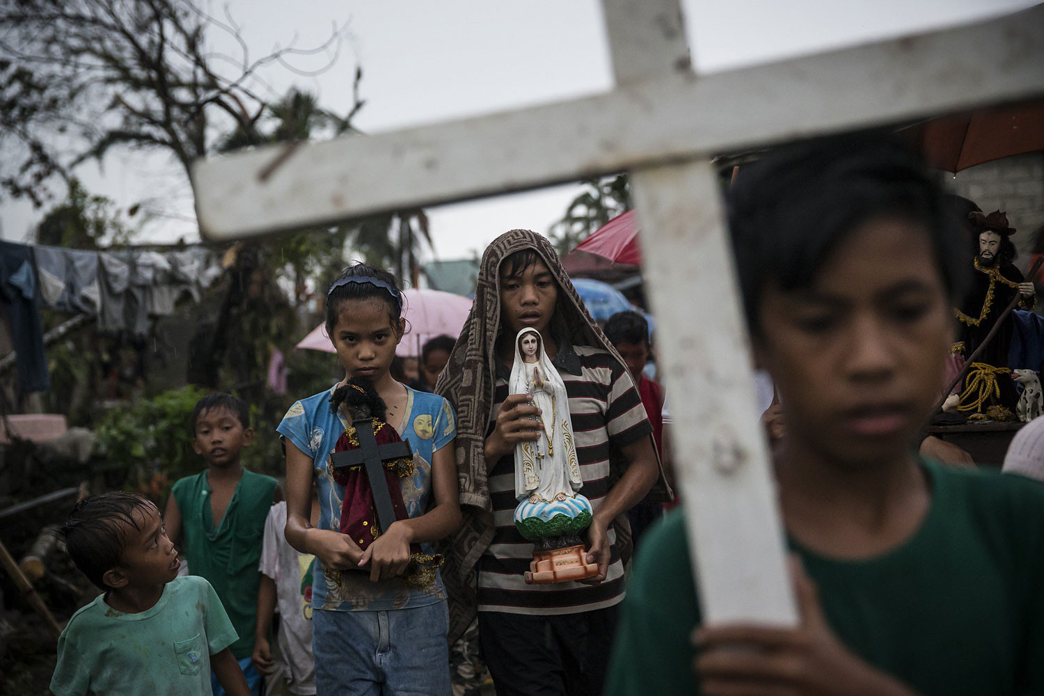 Villagers carry religious statues during a procession before taking part in a Latin mass ceremony at a local Chapel in Santa Rita township on November 22, 2013 in Eastern Samar, Philippines.