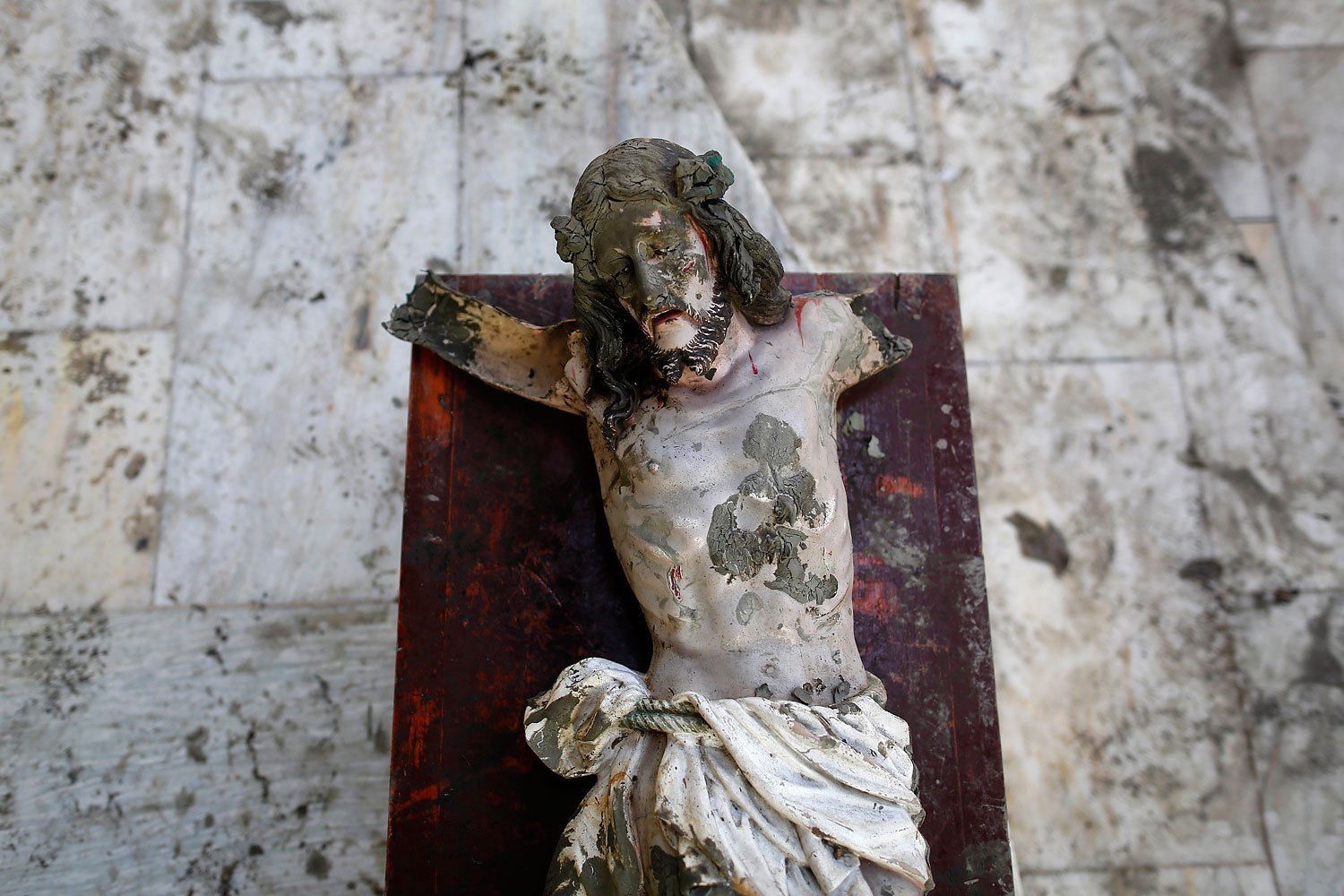 A damaged statue of Jesus Christ that was recovered from rubbles is placed in a church in an area wrecked by Typhoon Haiyan in Tacloban November 21, 2013.