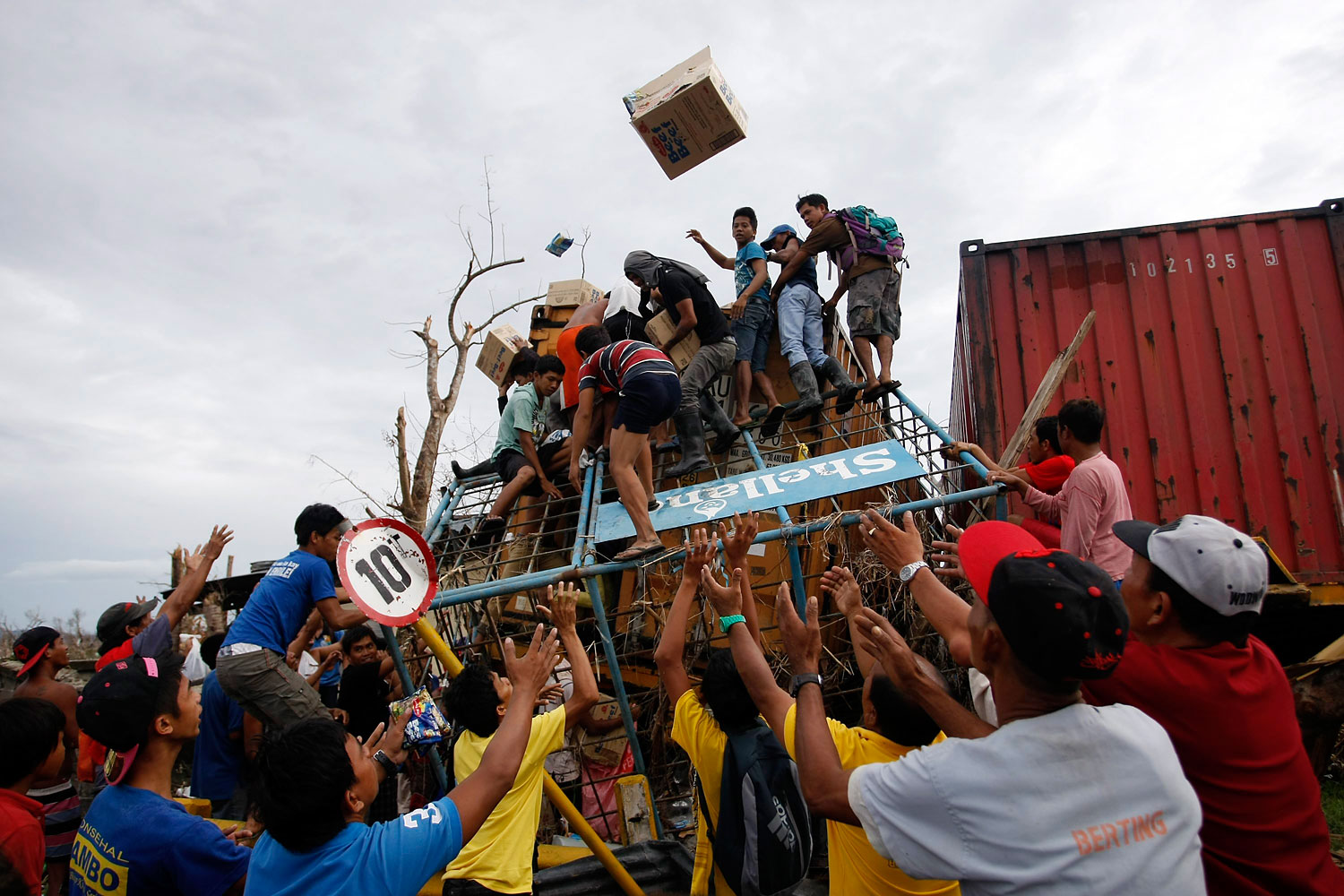 Filipino villagers force open a washed up container containing grocery items in the super typhoon devastated city of Tacloban, Leyte island province, Philippines, November 20, 2013.