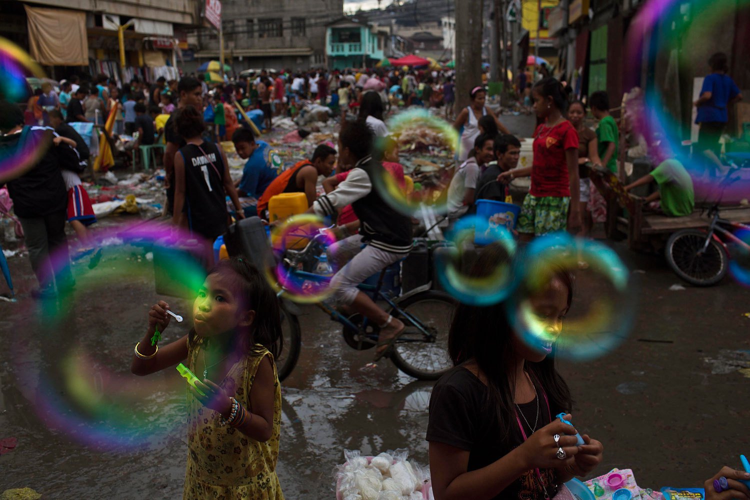 Children who survived Typhoon Haiyan blow bubbles in the destroyed market of Tacloban, Philippines, November 20, 2013.