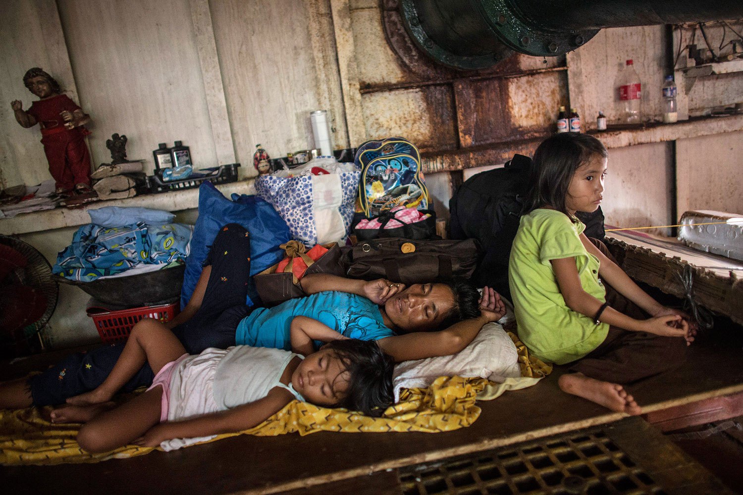 A family sleeps in the hull of a tanker in a particularly badly damaged part of Tacloban on November 19, 2013 in Leyte, Philippines.
