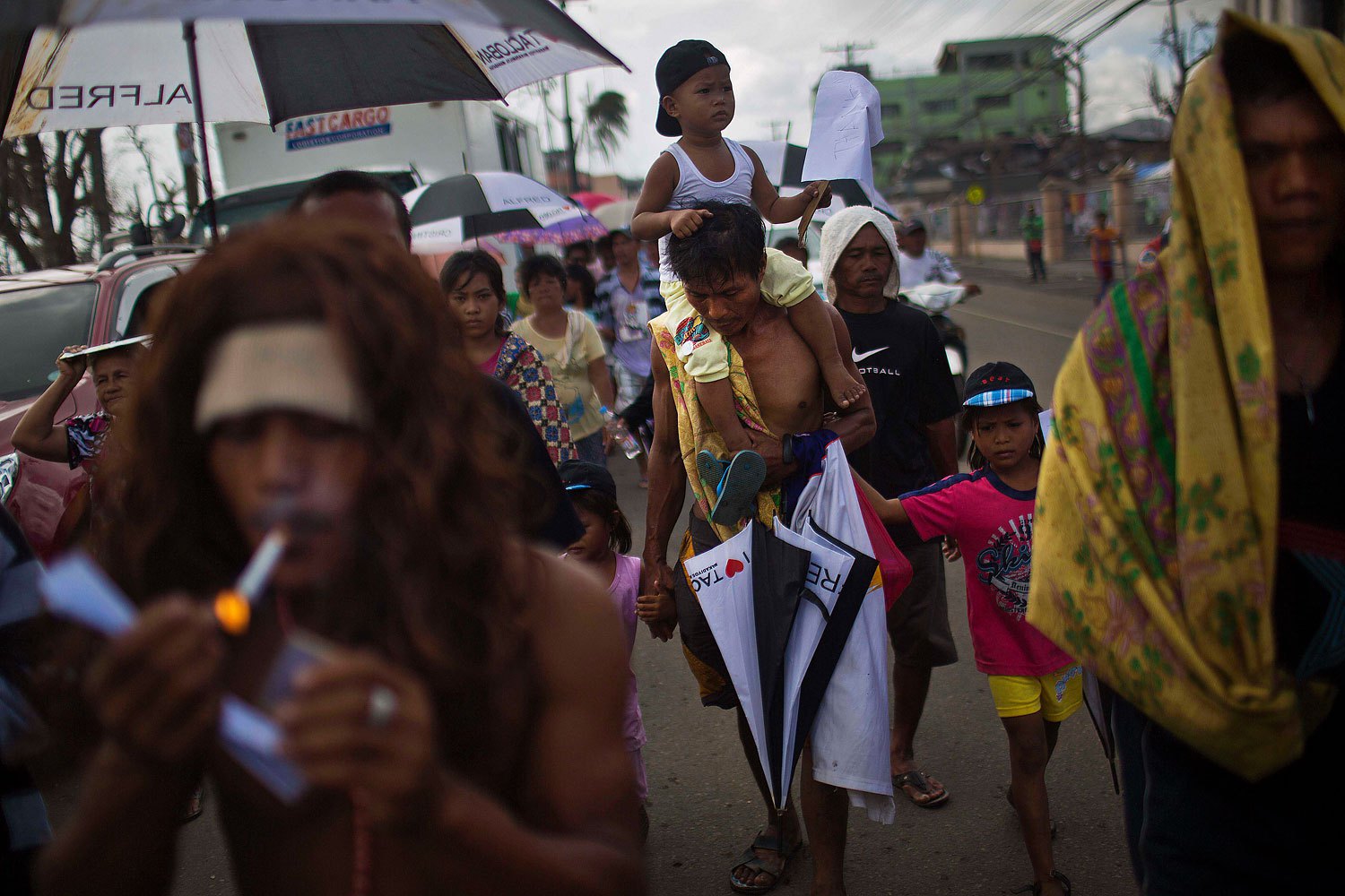 People march in the rain Tacloban, Philippines during a procession to call for courage and resilience among their Typhoon Haiyan survivors on November 19, 2013.