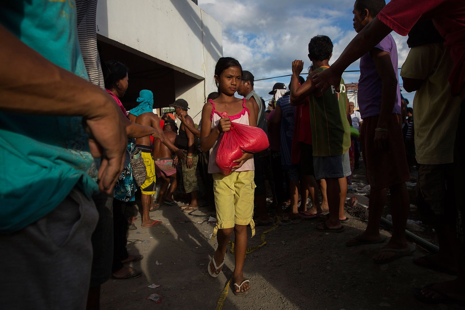 A girl affected by Typhoon Haiyan collects food aid in Tanauan, Philippines on November 19, 2013.
