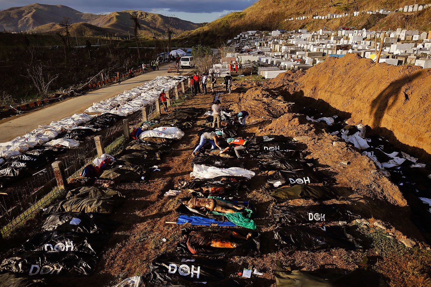 Forensic experts work on a mass grave with more than 700 bodies of victims of Typhoon Haiyan just outside Tacloban on November 18, 2013.