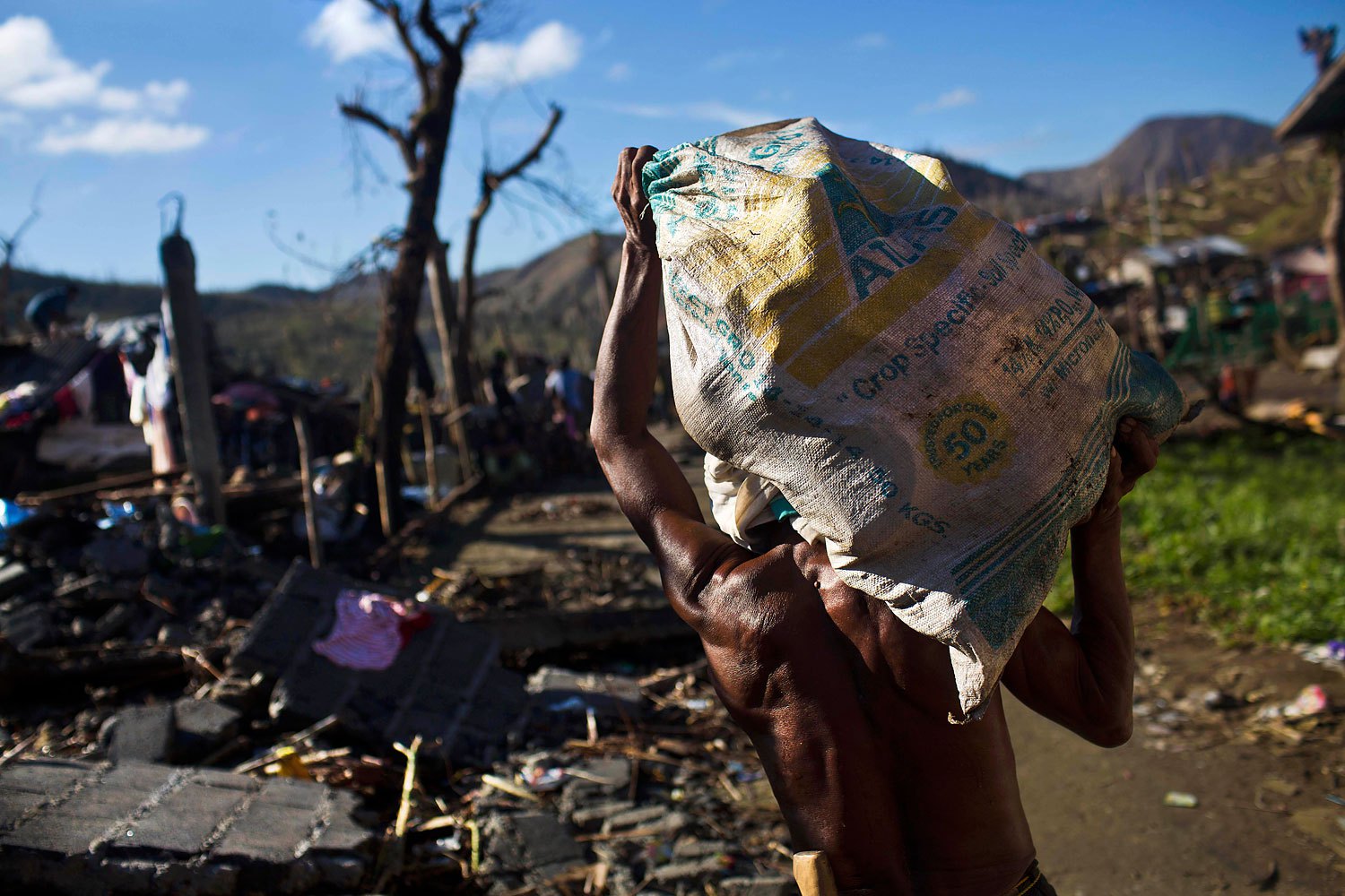 A Typhoon Haiyan survivor carries a bag of his recovered belongings in the ruins of his rural neighborhood on the outskirts of Tacloban, Philippines on November 18, 2013.