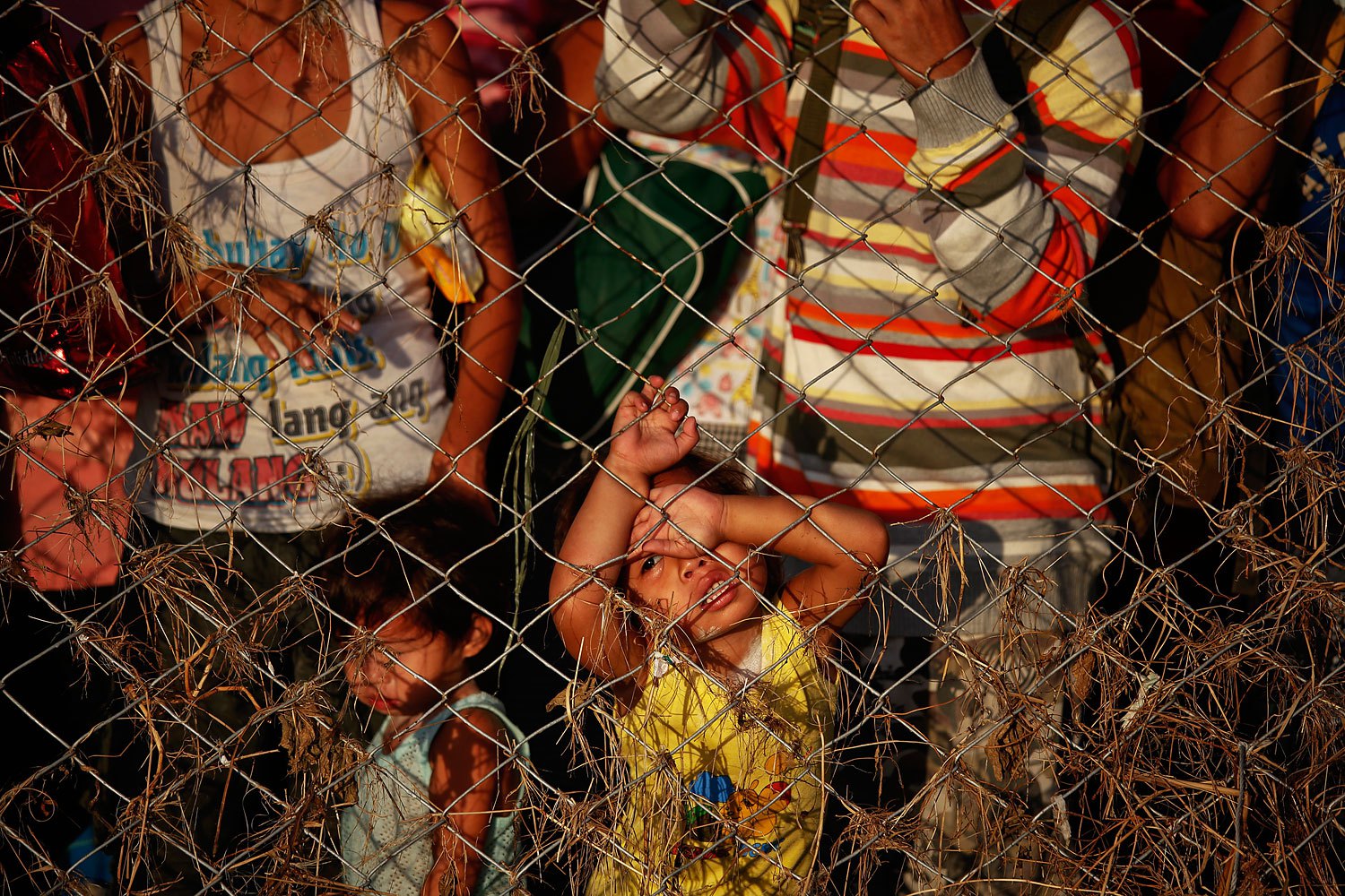 People who trying to leave the devastated town look through the fence of Tacloban airport, which remains a point of exodus for survivors of typhoon Haiyan, November 17, 2013.