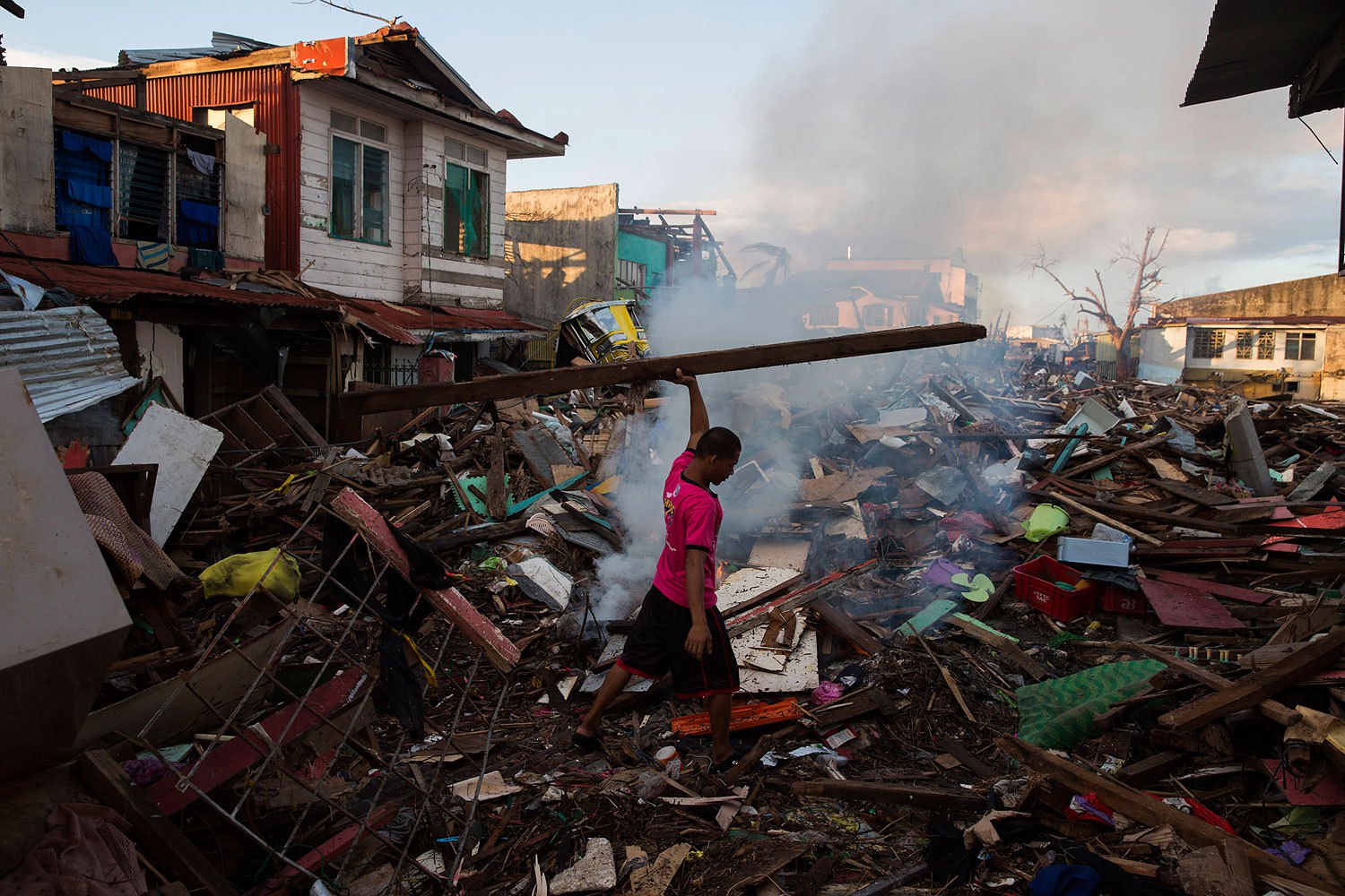 A man salvages wood in a neighbourhood destroyed by Typhoon Haiyan in Tacloban, Philippines on November 17, 2013.