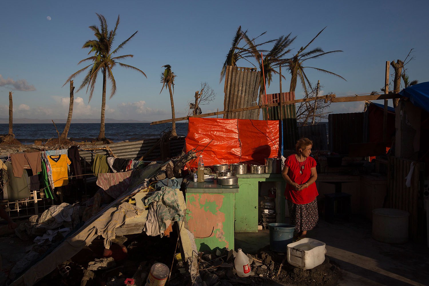 A woman stands in the kitchen of her home destroyed by Typhoon Haiyan in Tanuan, Philippines on November 15, 2013.