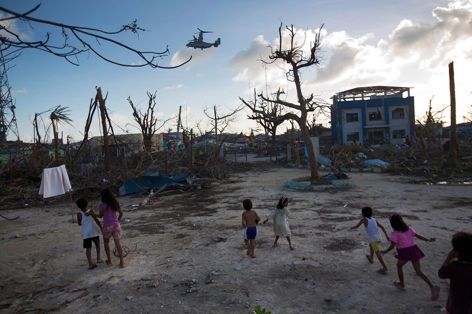 Children run towards a U.S. military aircraft as it arrives to distribute aid to Typhoon Haiyan survivors in the destroyed town of Guiuan, Philippines on November 14, 2013.