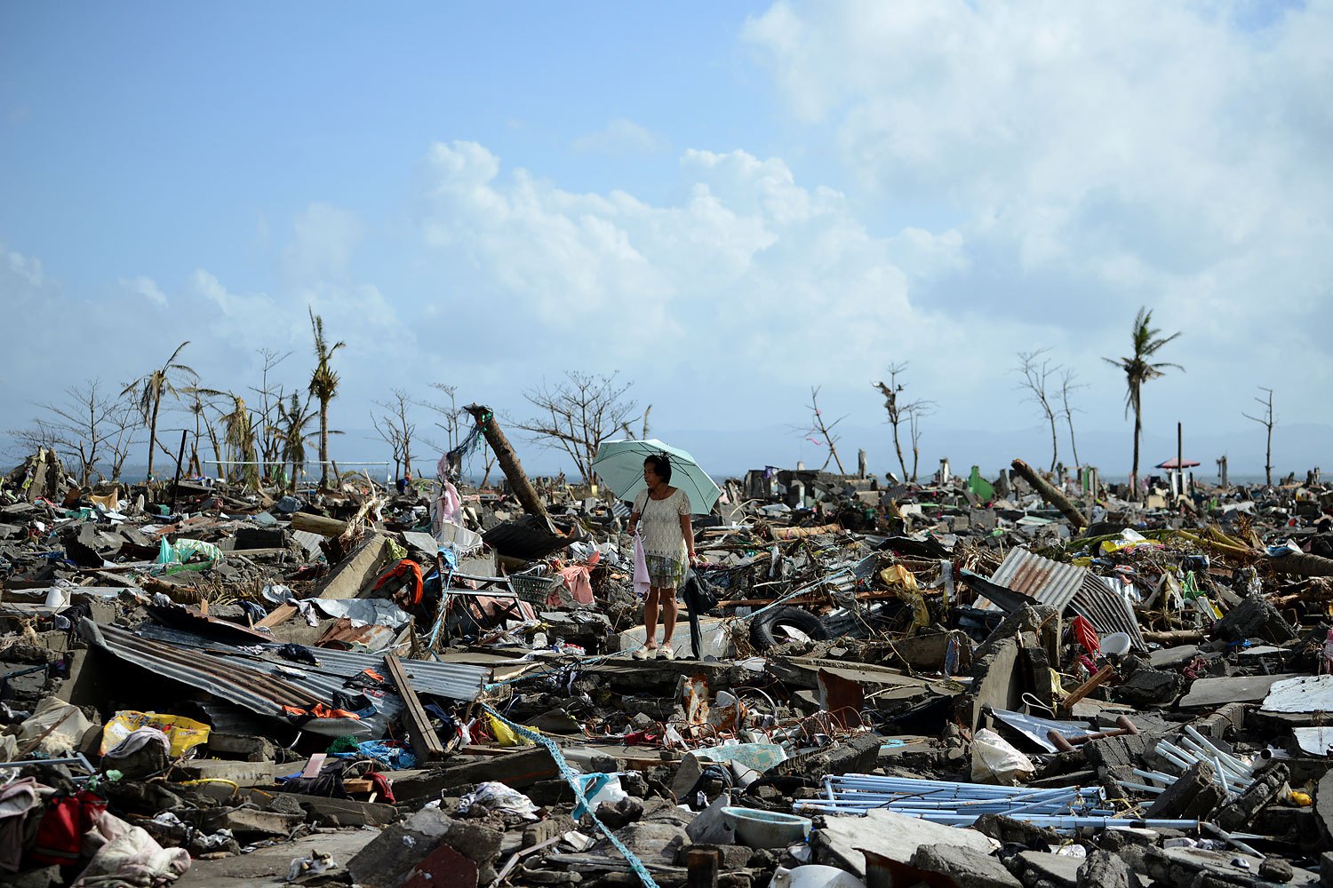 A surivor walks among the debris of houses destroyed by Super Typhoon Haiyan in Tacloban in the eastern Philippine island of Leyte on November 11, 2013.