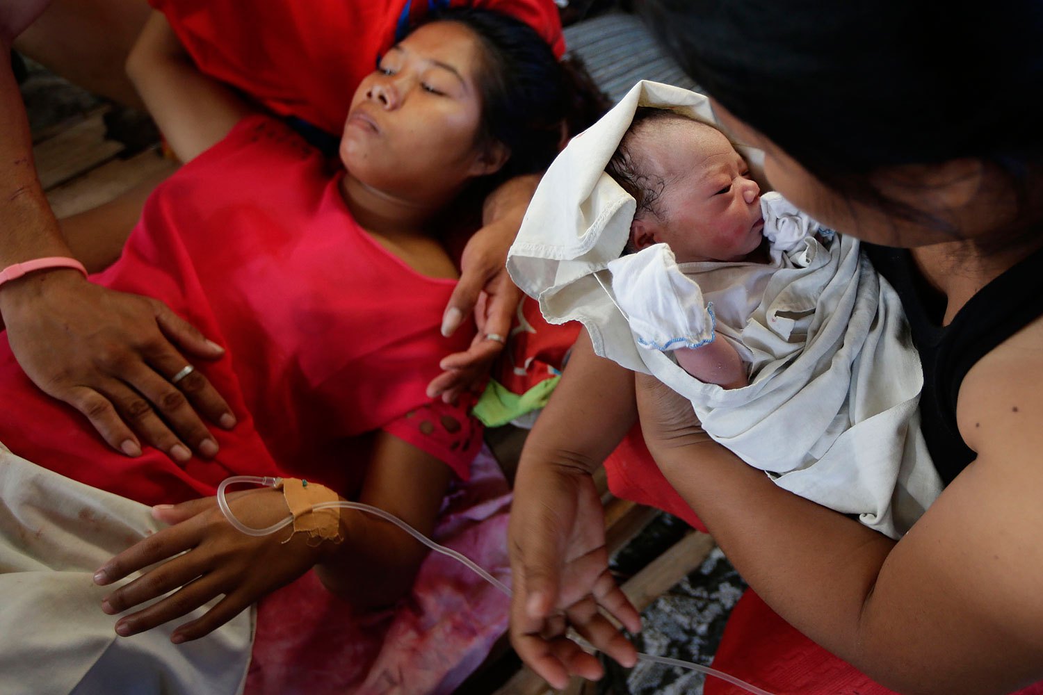 Emily Ortega, 21, gives birth to baby girl Bea Joy, after being in labor for five hours at an improvised clinic at Tacloban Airport in Tacloban city, central Philippines.