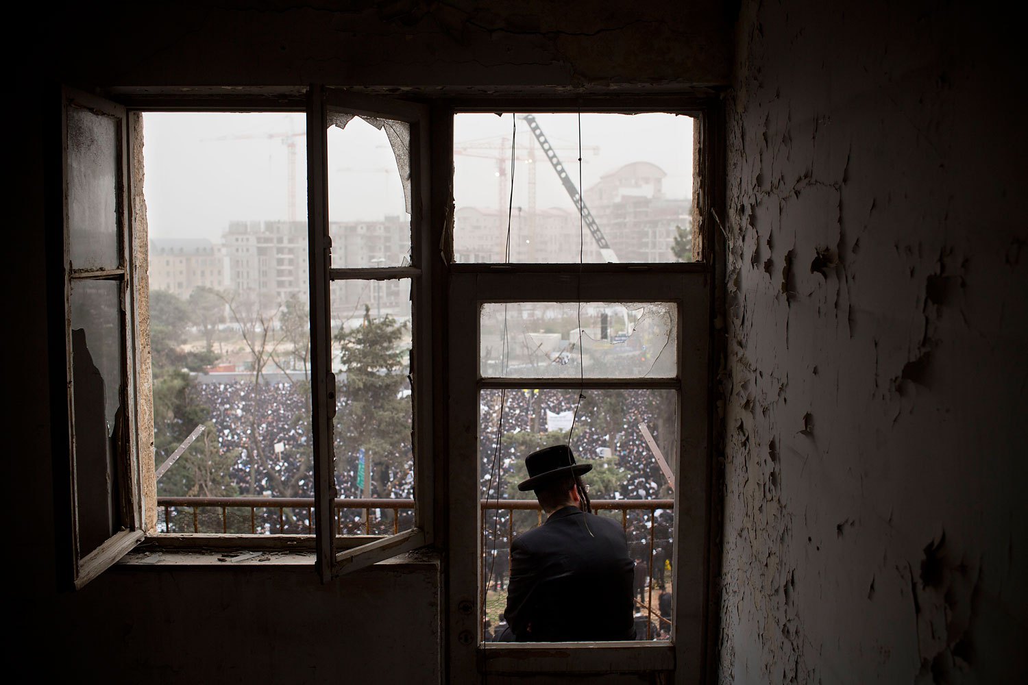An ultra-Orthodox Jewish man watches from a balcony as hundreds of thousands of ultra-Orthodox Jews rally in a massive show of force against plans to force them to serve in the Israeli military, blocking roads and paralyzing the city of Jerusalem, March 2, 2014.