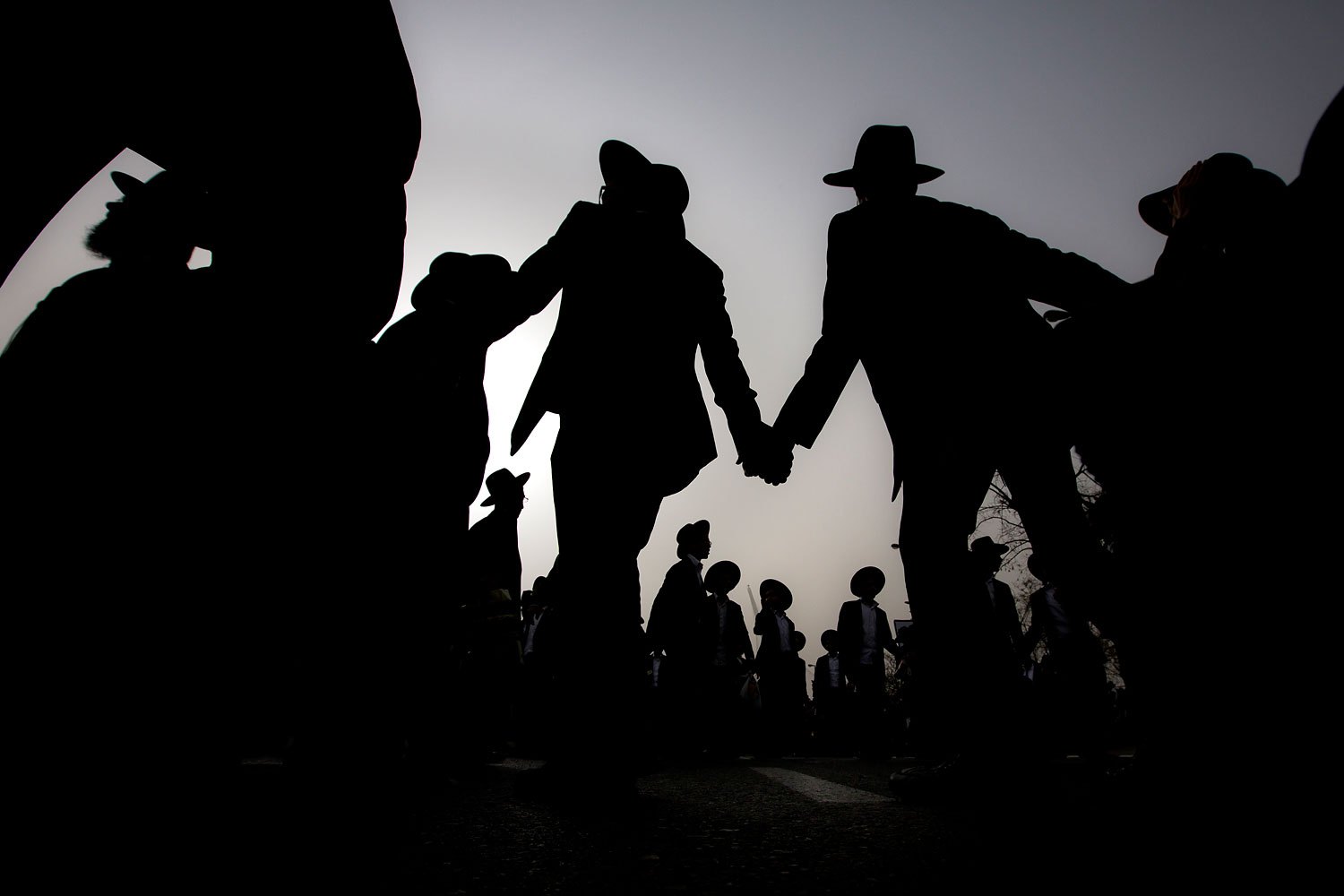 Ultra-Orthodox Jewish men dance at a rally in a massive show of force against plans to force them to serve in the Israeli military, blocking roads and paralyzing the city of Jerusalem, March 2, 2014.