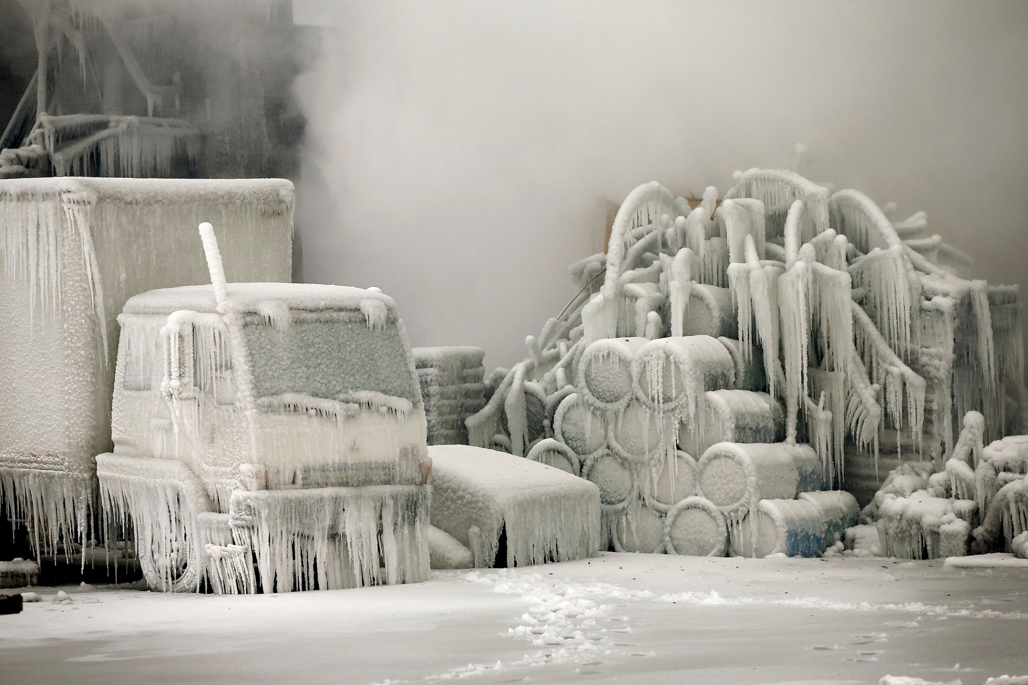 A truck is covered in ice as firefighters help to extinguish a massive blaze at a vacant warehouse on January 23, 2013 in Chicago. More than 200 firefighters battled a five-alarm fire as temperatures were in the single digits.