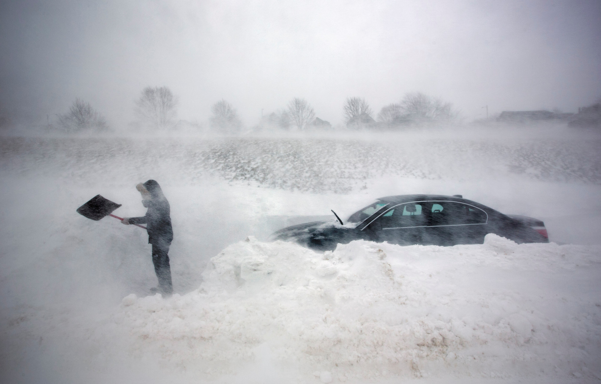 A woman digs out her car after it was blocked in by drifting snow during a blizzard, Feb. 9, 2013, in Portland, Maine. The storm dumped more than 30 inches of snow as of Saturday afternoon, breaking the record for the biggest storm on record.