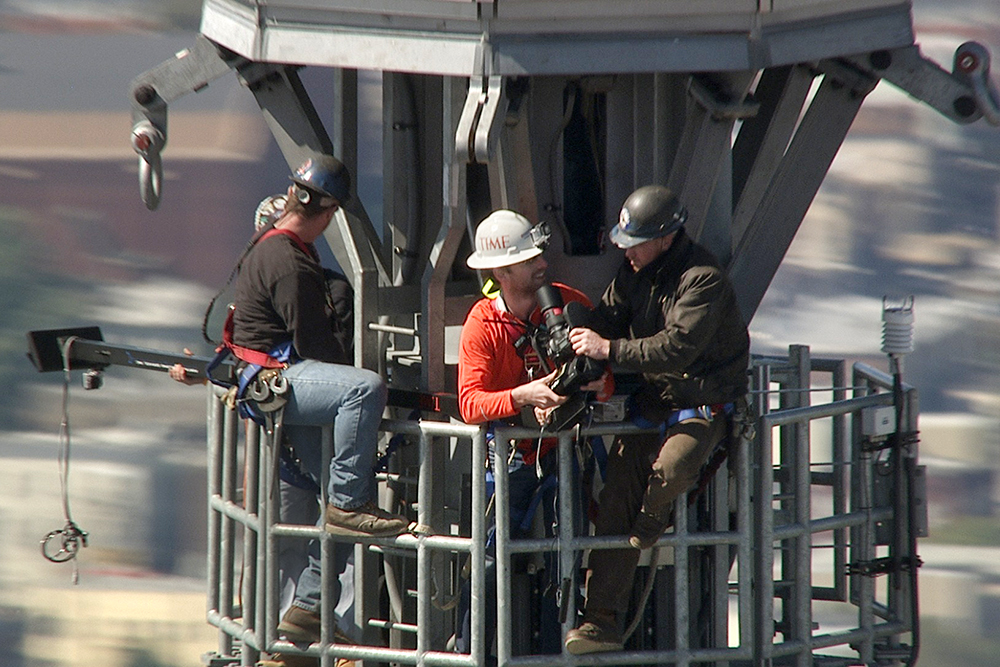 Jim Brady, far right, and TIME's Jonathan Woods, second from right, on the spire of 1 World Trade Center (Doug Holgate — New York on Air for TIME)