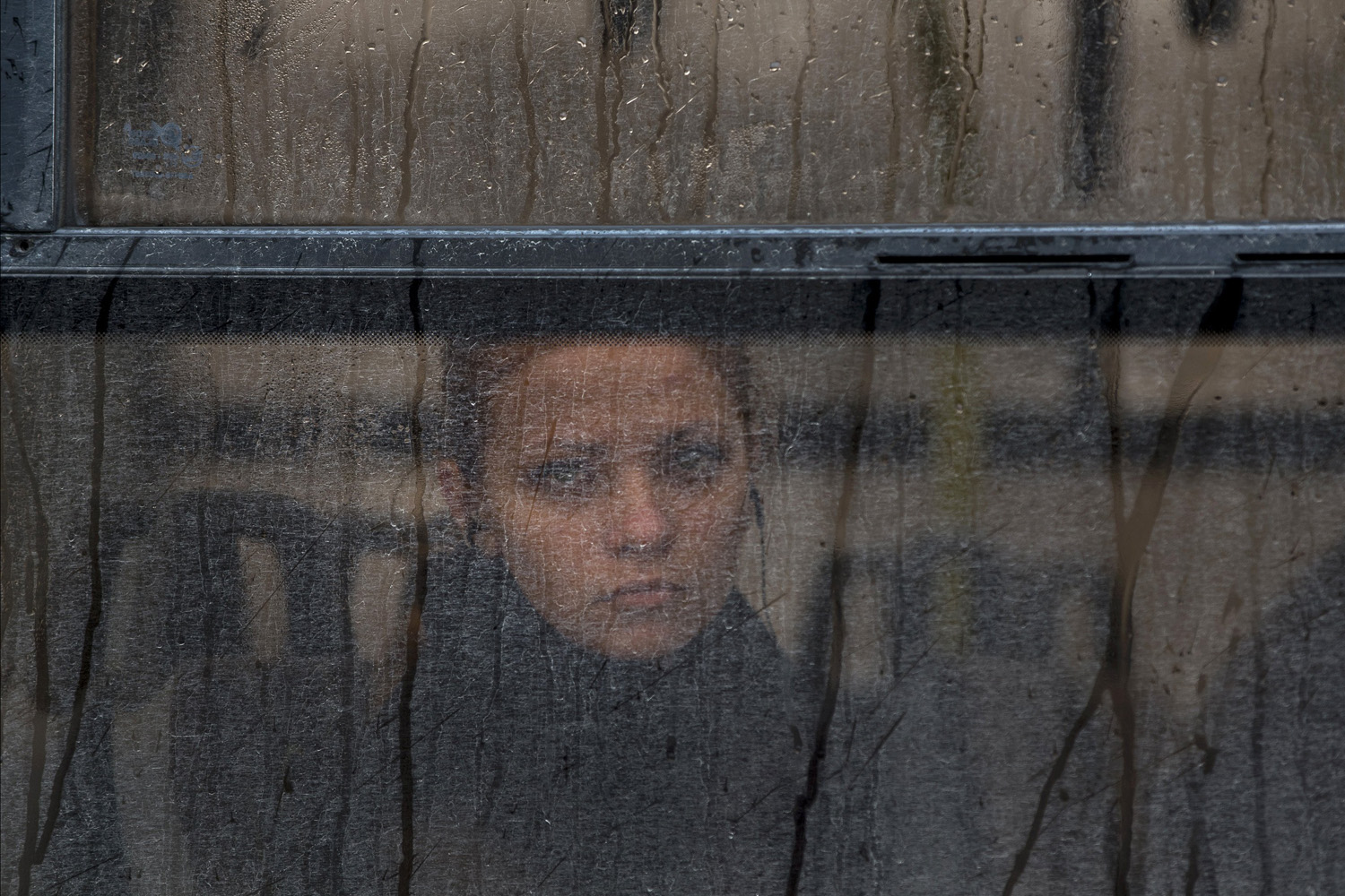 Mar. 7, 2014. A woman watches a rally against the breakup of the country from behind the tinted window of a bus in Simferopol, Ukraine.