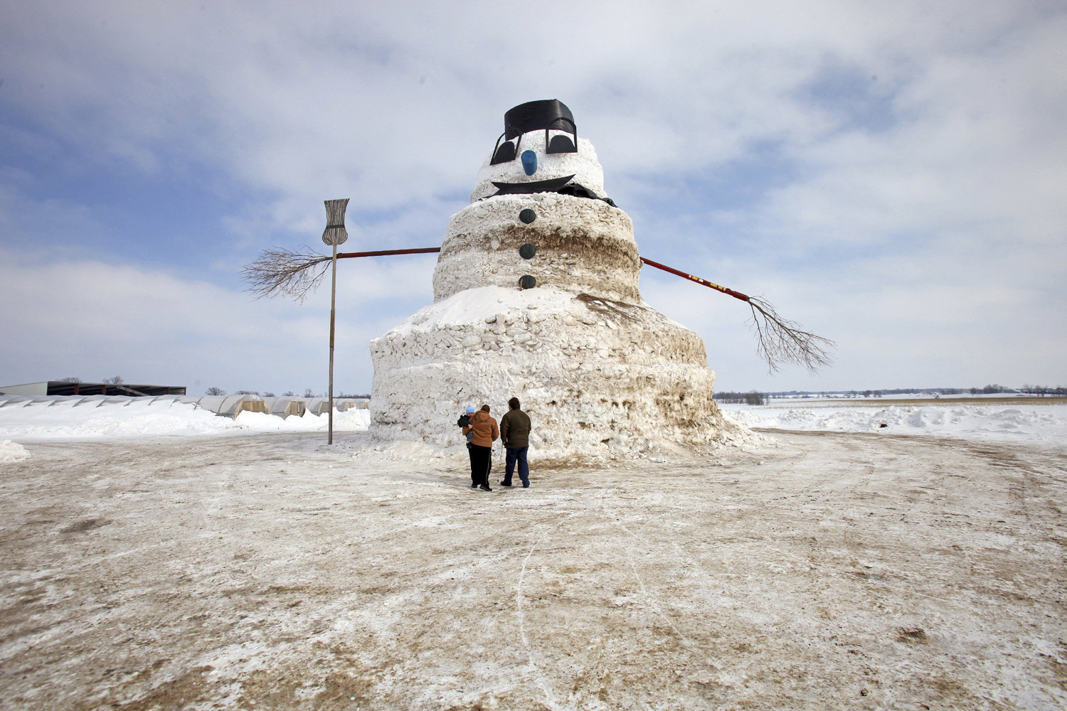Mar. 6, 2014. A couple and a child look at a 50-foot snowman named  Granddaddy  in Gilman, Minnesota.