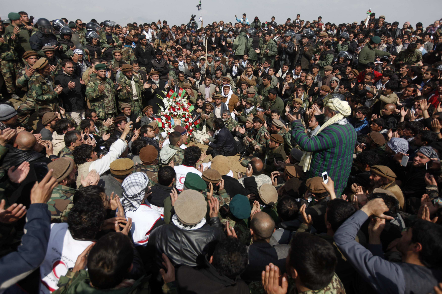 Afghans pray over the grave of Afghan Vice-President Marshal Fahim after he was buried in Kabul