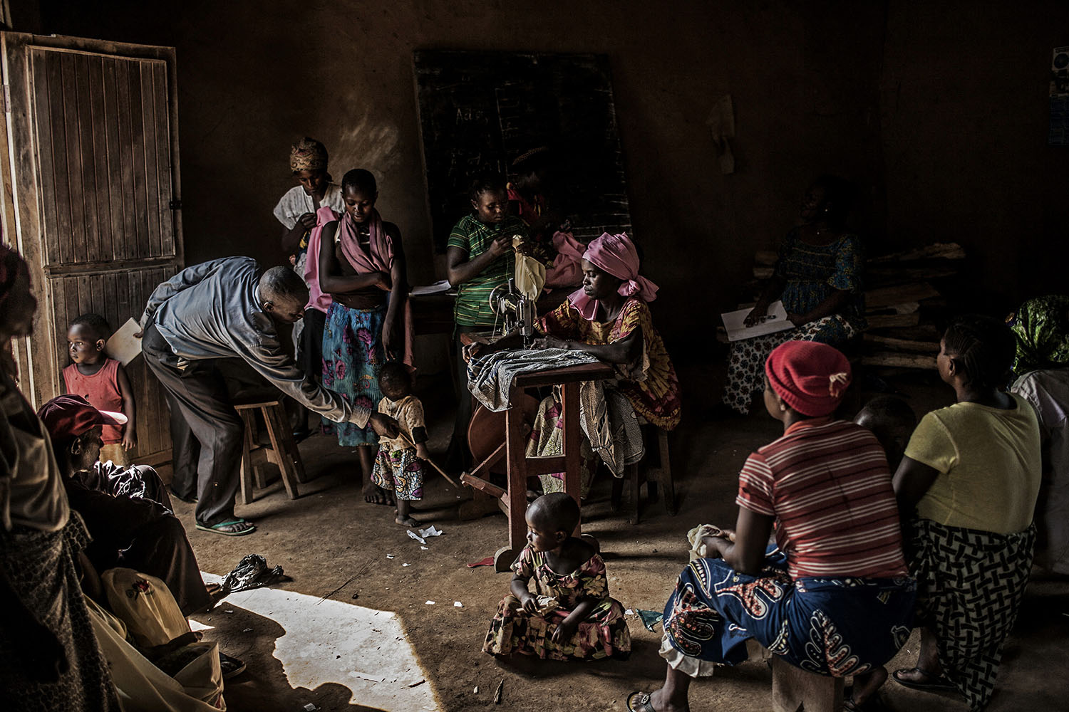 Mar. 3, 2014. Residents gather inside a makeshift sewing studio in the village of Mangango, in the eastern Democratic Republic of Congo.