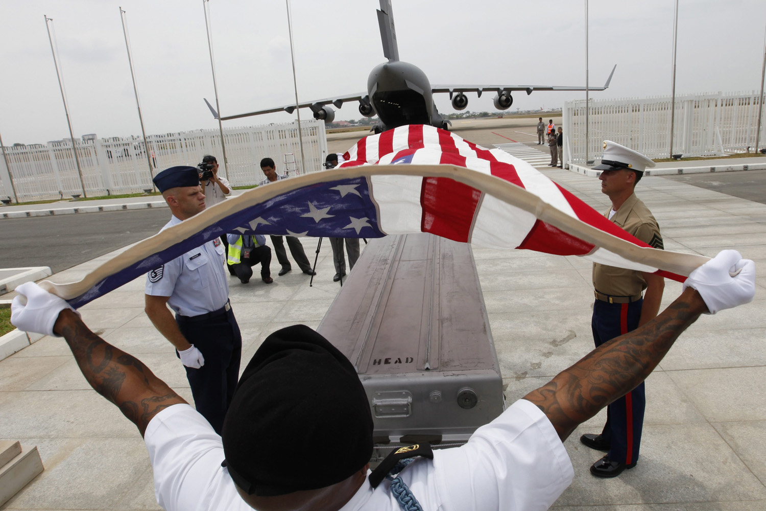 Apr. 2, 2014. US service personnel cover a coffin with a US flag during a repatriation ceremony at Phnom Penh International airport, Cambodia.  Cambodia and the US conducted a repatriation ceremony to honor the recovery of possible remains believed to belong to missing US military service members found.