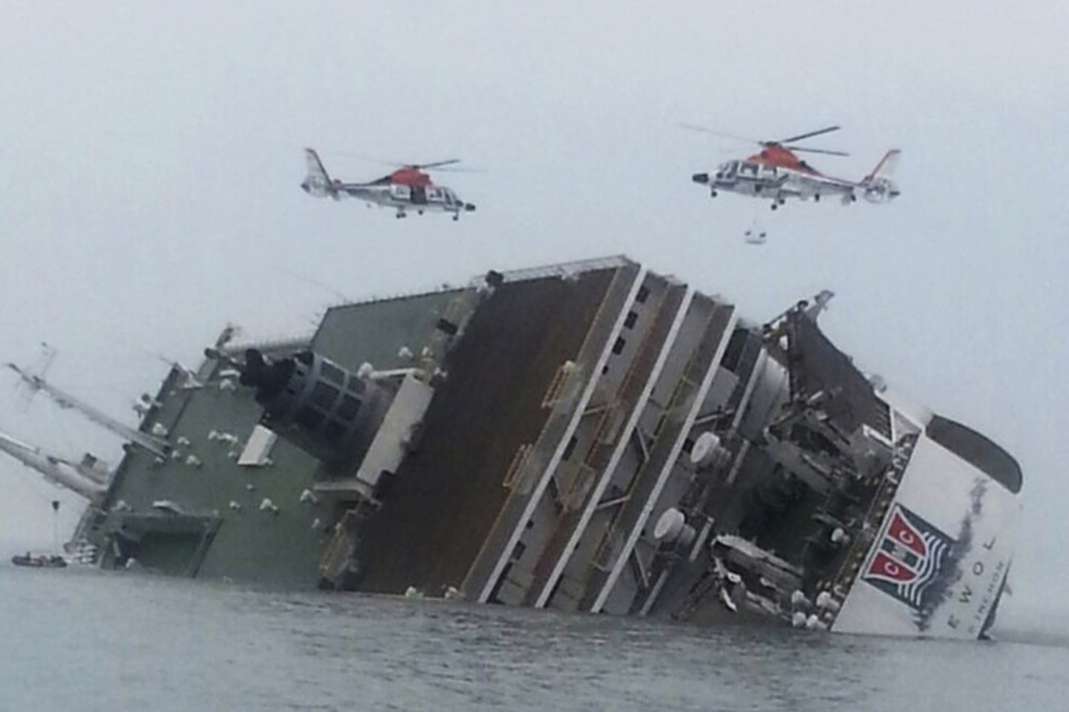 Rescue helicopters flying over the passenger ship <em>Sewol</em> as it sinks in waters off South Korea's southwestern coast on April 16, 2014 (Yonhap—EPA)