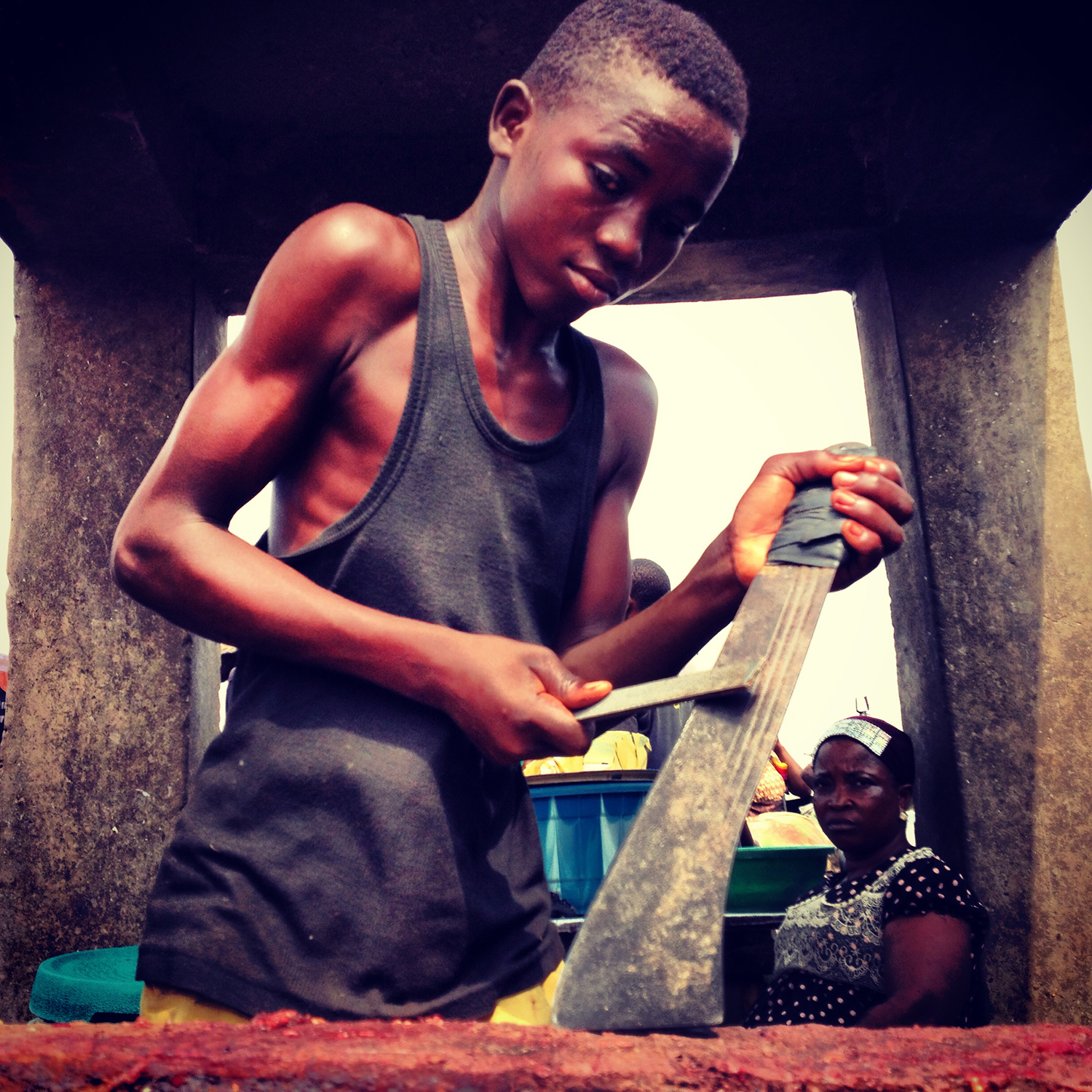 Feb. 13, 2014. A young butcher sharpening his machete to slaughter the herds of cattle that are brought to their abattoir along the Lagos-Ibadan express road.