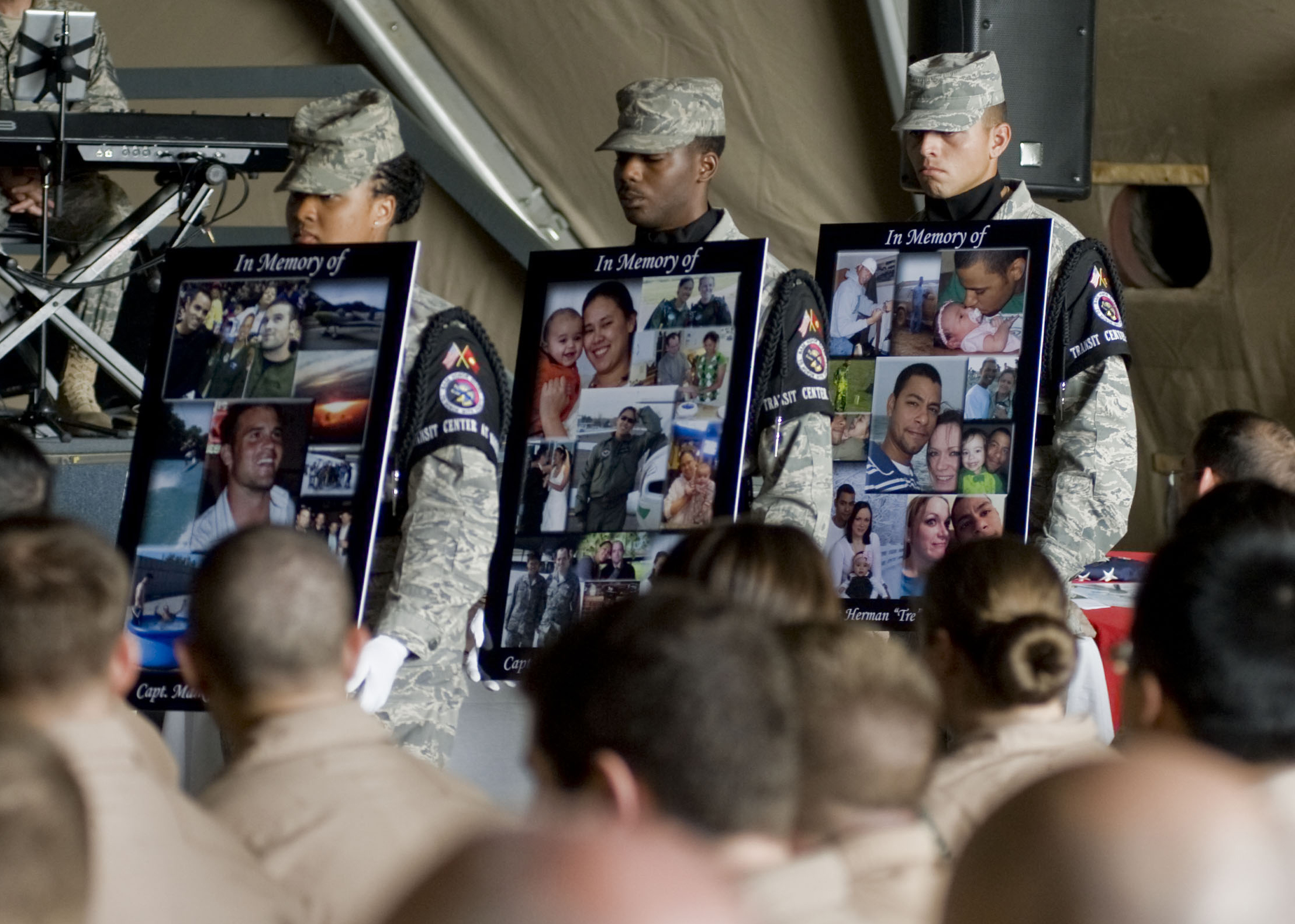 An honor guard carries photos of the KC-135 crew members during a memorial service at Manas six days after the crash. (SSgt. Stephanie Rubi / Air Force)