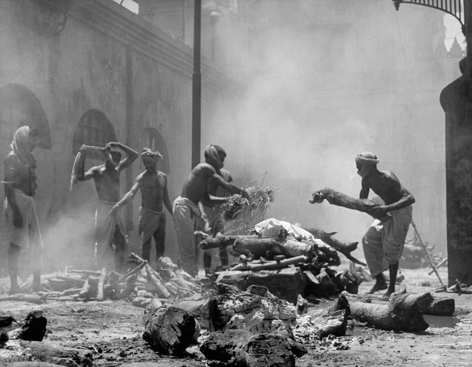 Men add wood and straw to funeral pyres in preparation for cremation of corpses after bloody rioting between Hindus and Muslims, Calcutta (now Kolkata), India, 1946.