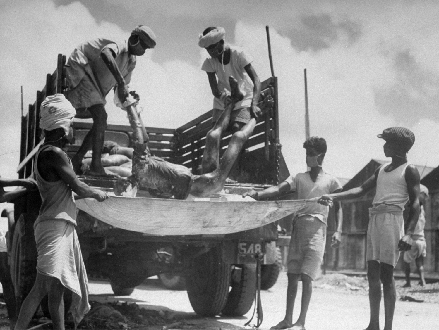 Men unload corpses from a truck in preparation for cremation after bloody rioting between Hindus and Muslims, Calcutta (now Kolkata), India, 1946.