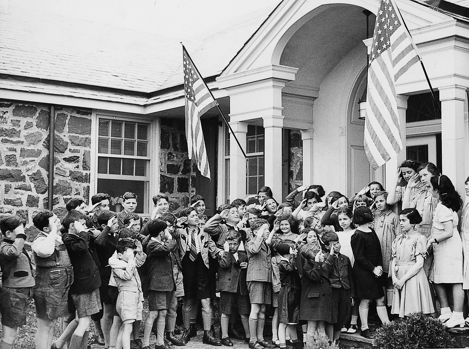 The children salute the American flag at the Brith Sholom house in Collegeville, Penn. Gil and Eleanor’s son, Steven, is standing in the top row between two saluting boys. To the lower left of the flag, their daughter, Ellen, is in a white dress.