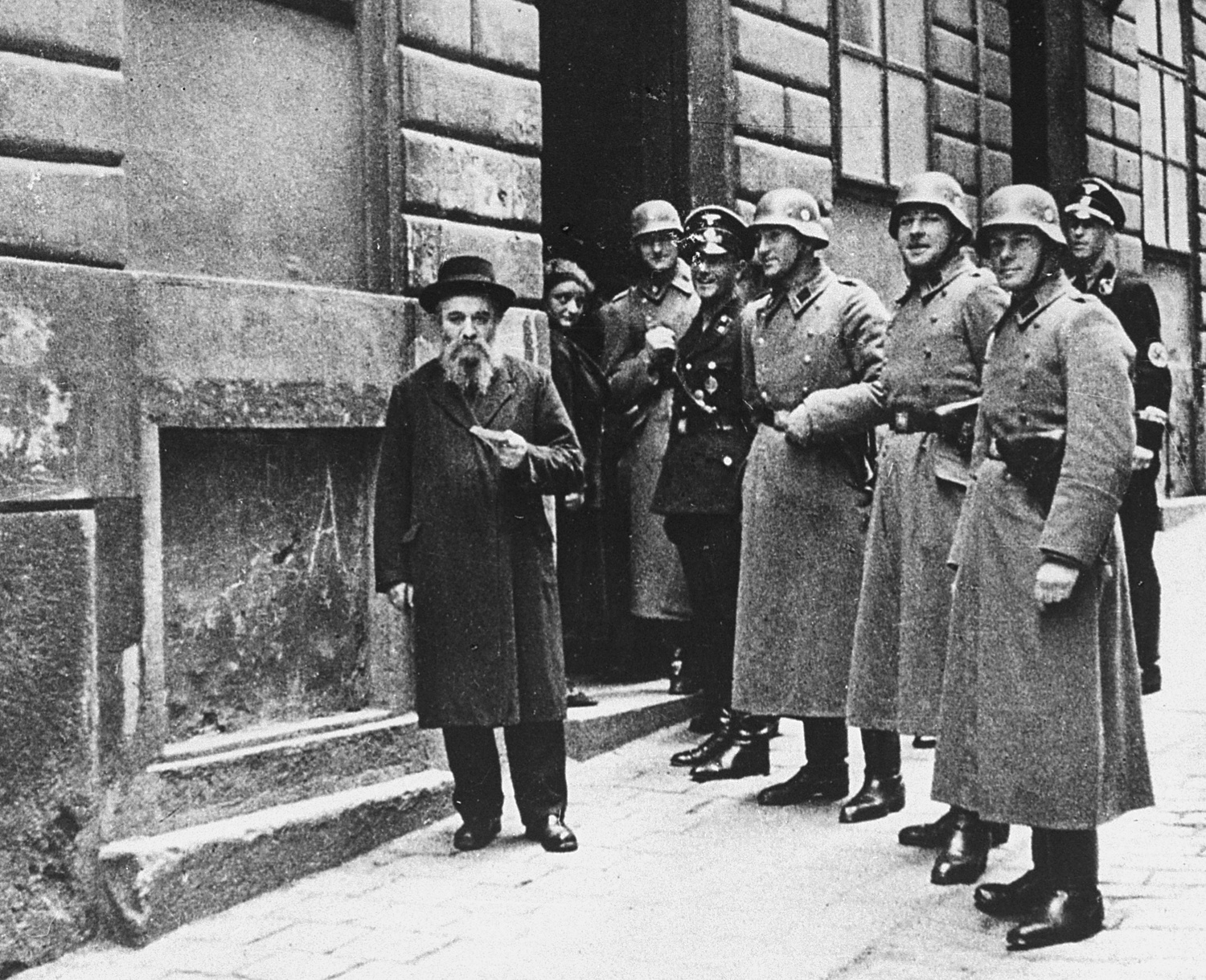 An elderly Jewish man and Gestapo officers and troops, Germany, late 1930s.
