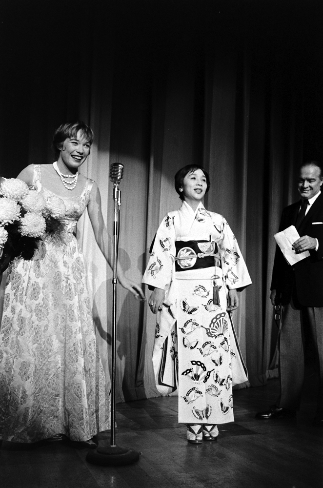 Shirley MacLaine on stage (Bob Hope at right) during the Las Vegas benefit she organized for victims of the Isewan Typhoon, 1959.
